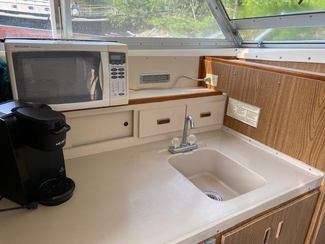 1972 Bertram Express boat kitchen with sink, microwave, and coffee maker.