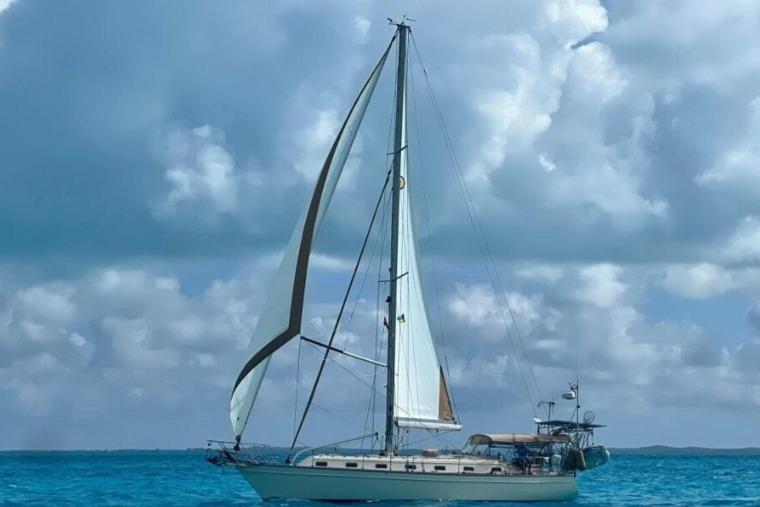 Sailboat Island Packet 420 (2000) cruising on turquoise waters under cloudy skies.