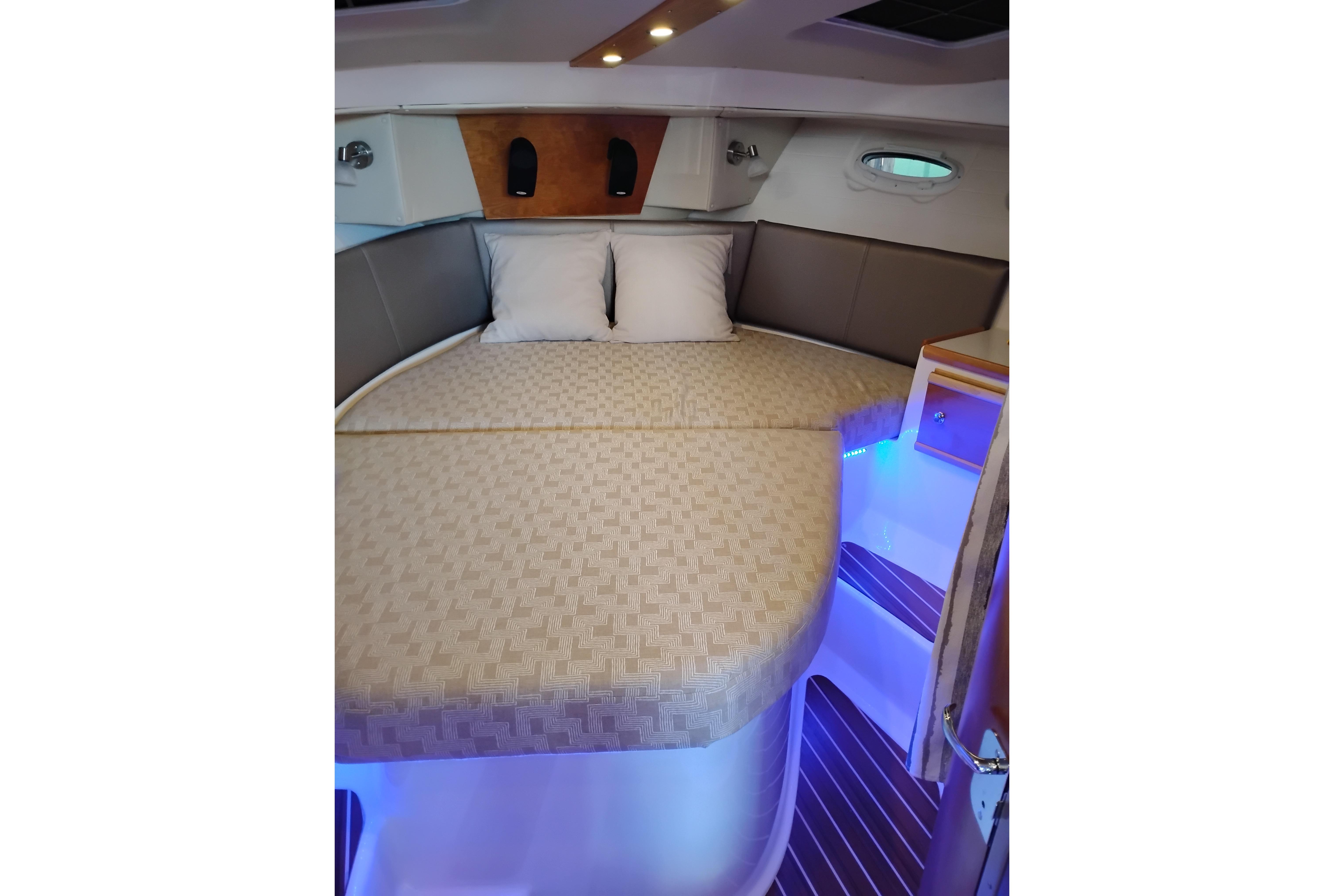 2022 Cutwater C-32 Coupe interior cabin with cozy bed and ambient lighting.