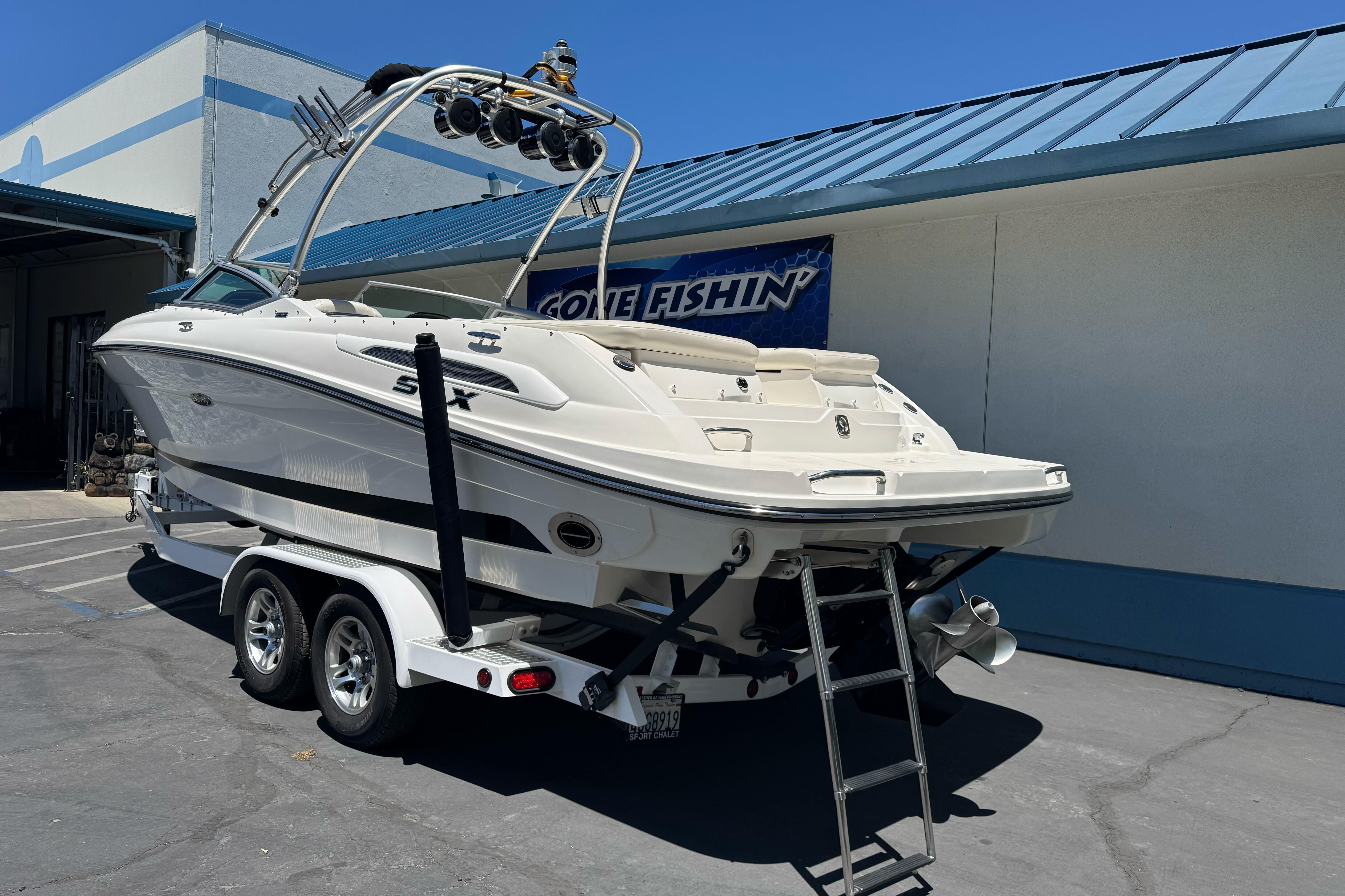2007 Sea Ray SLX 250 boat on trailer, parked outdoors near a building.