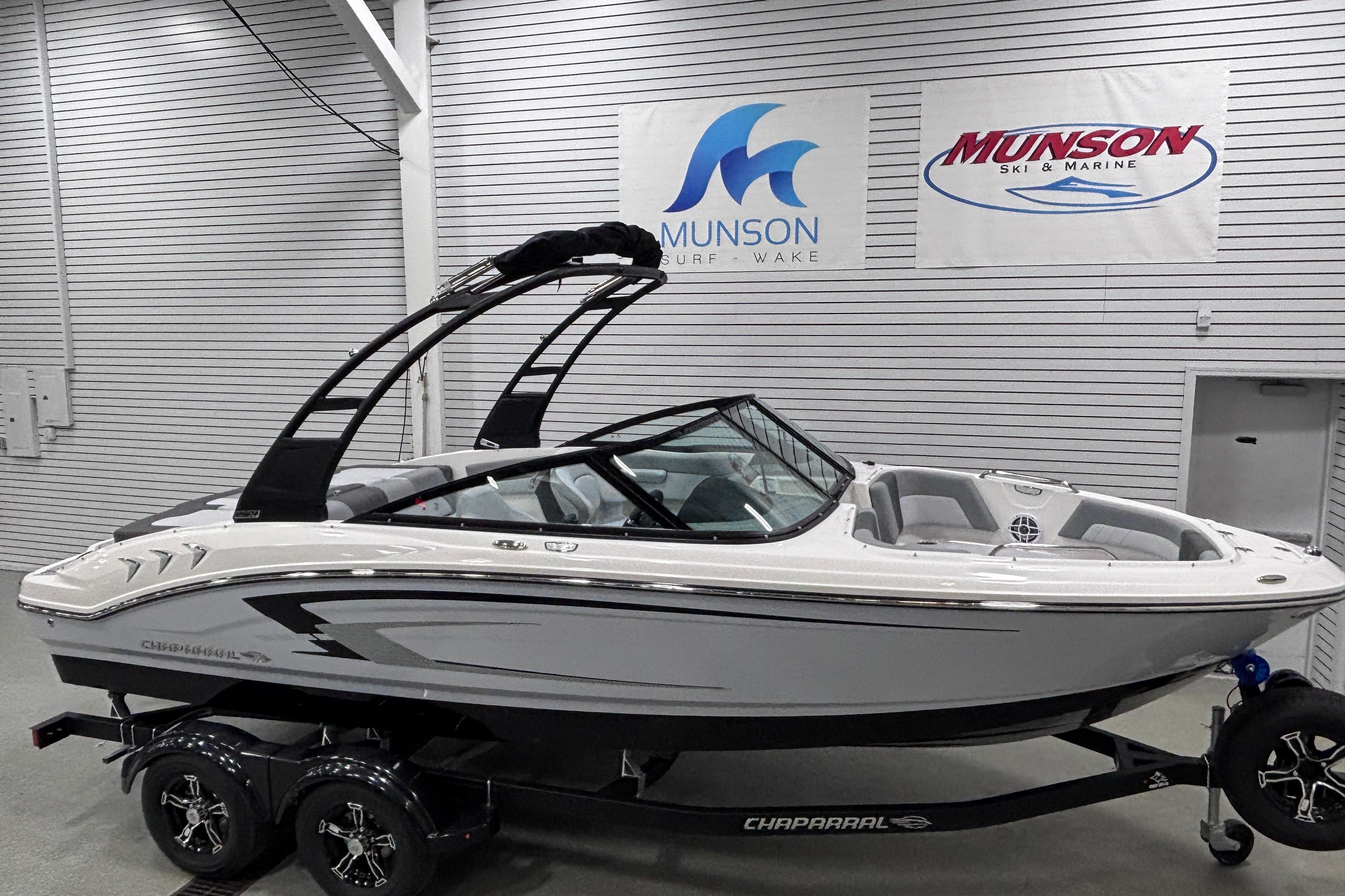 2026 Chaparral 21 SSi boat in showroom, sleek design, Munson Ski & Marine signage.
