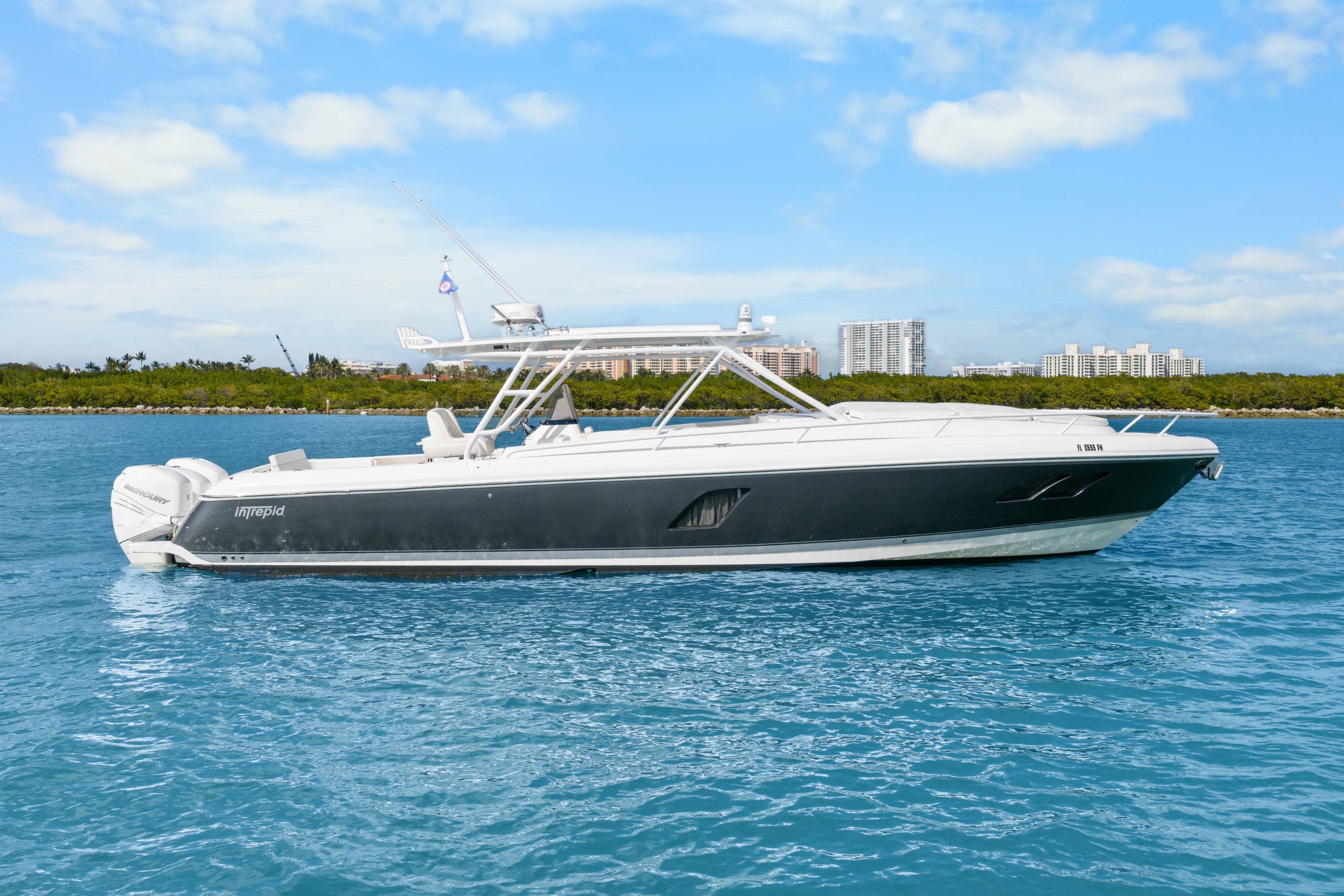 2013 Intrepid 400 Cuddy boat on blue water with city skyline background.