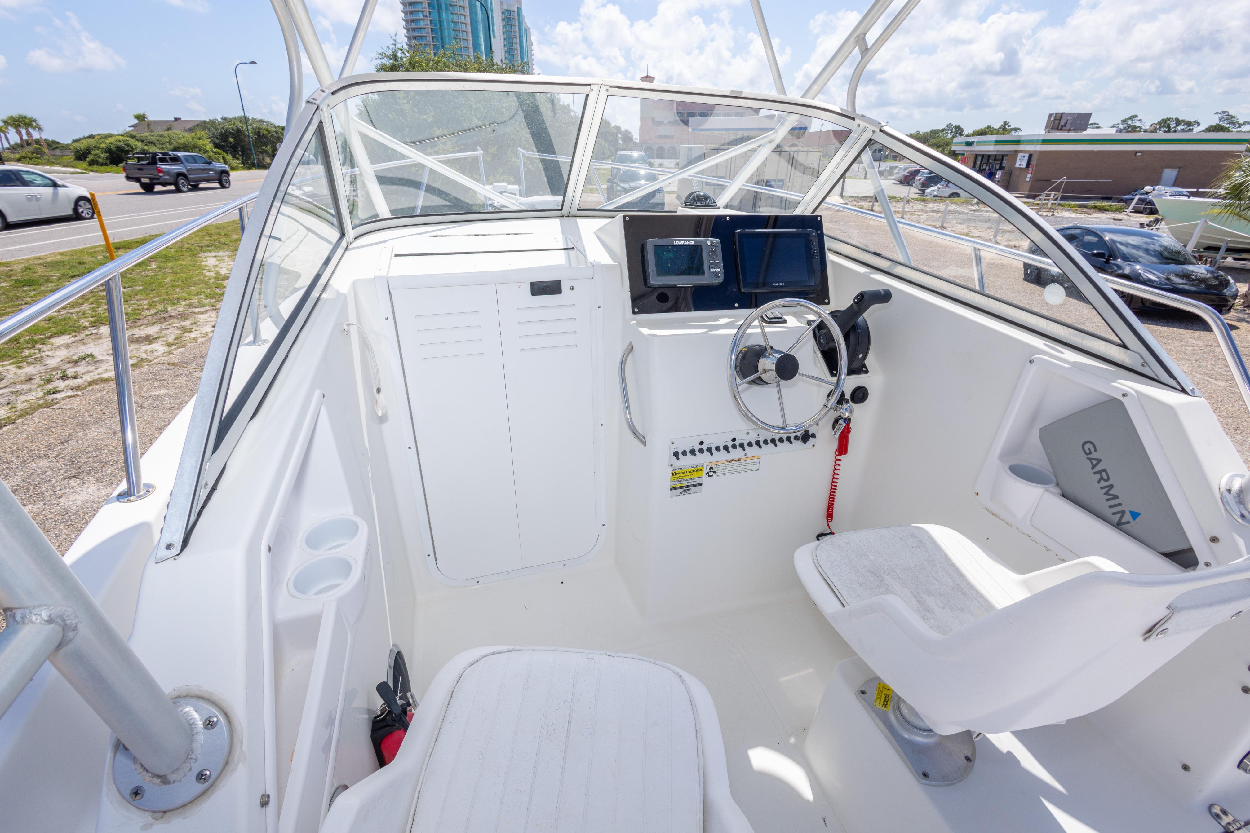 2007 Sea Boss 235 Walkaround boat cockpit with steering wheel and navigation equipment.