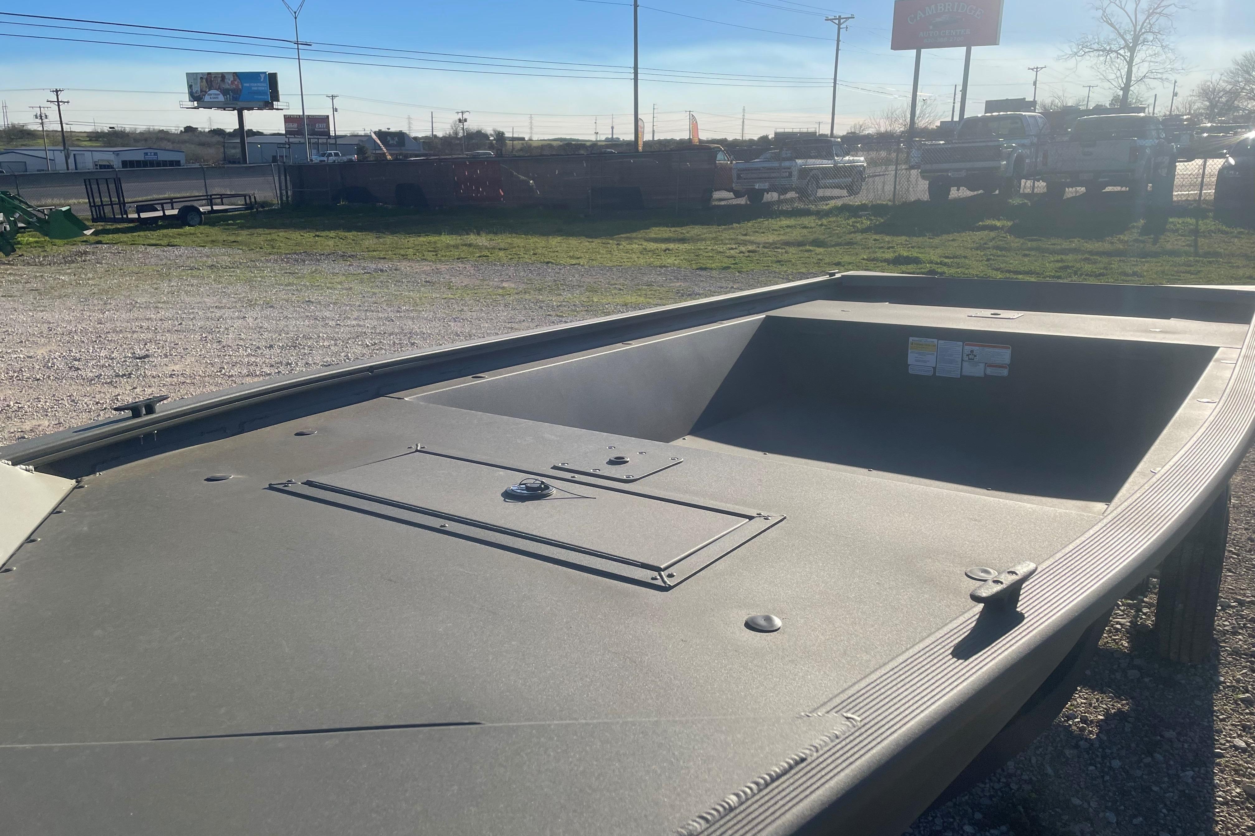 2026 Tracker Grizzly 1648 Utility boat on gravel lot.