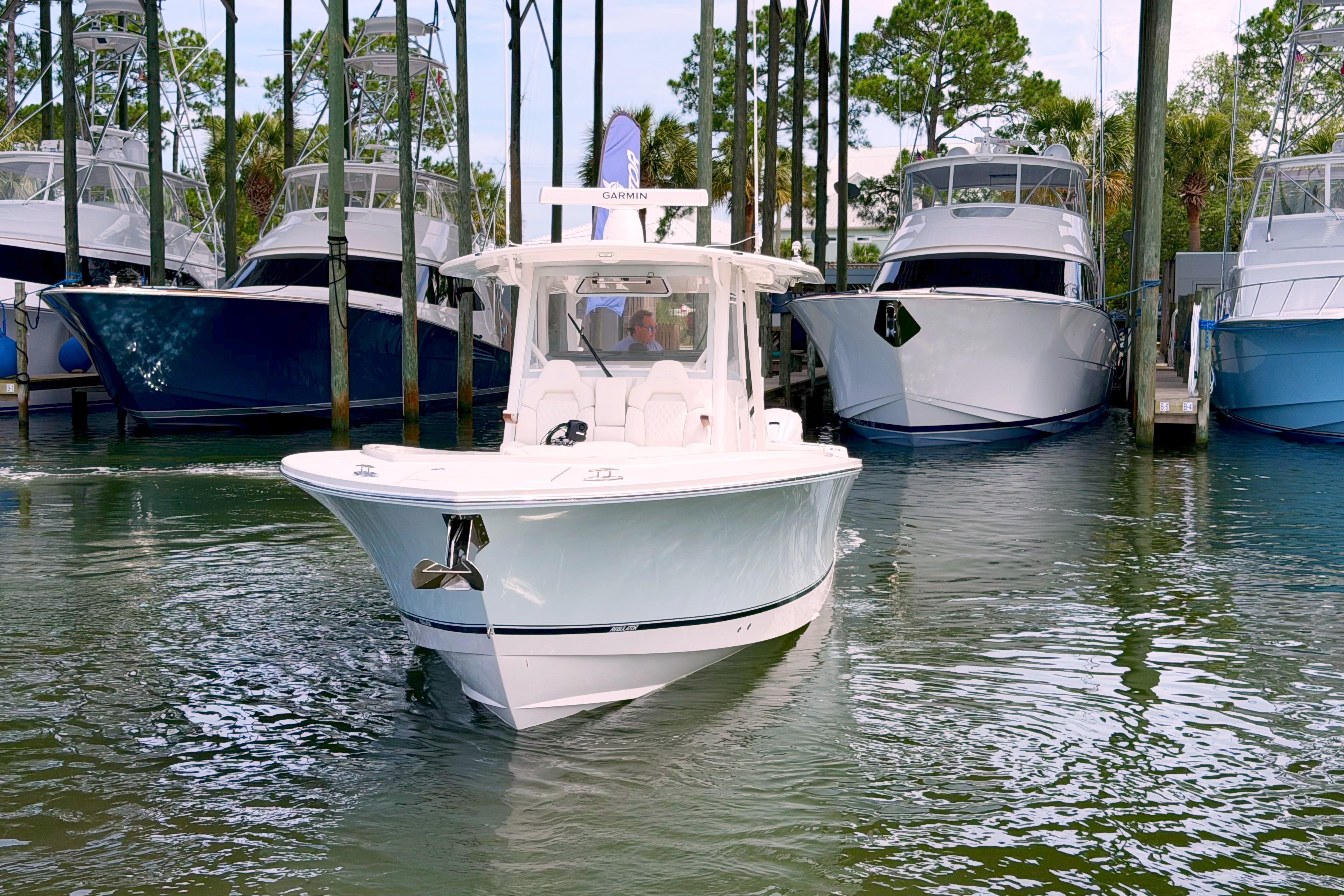 2026 Regulator 37 boat navigating marina, surrounded by docked yachts.