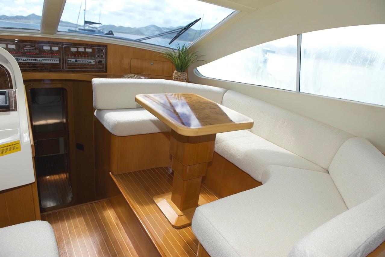 Luxurious interior of 2001 Raffaelli Maestrale 52 yacht with elegant seating and wooden table.