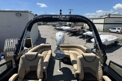 2025 SunCatcher Amara boat with beige seating, docked under a clear blue sky.