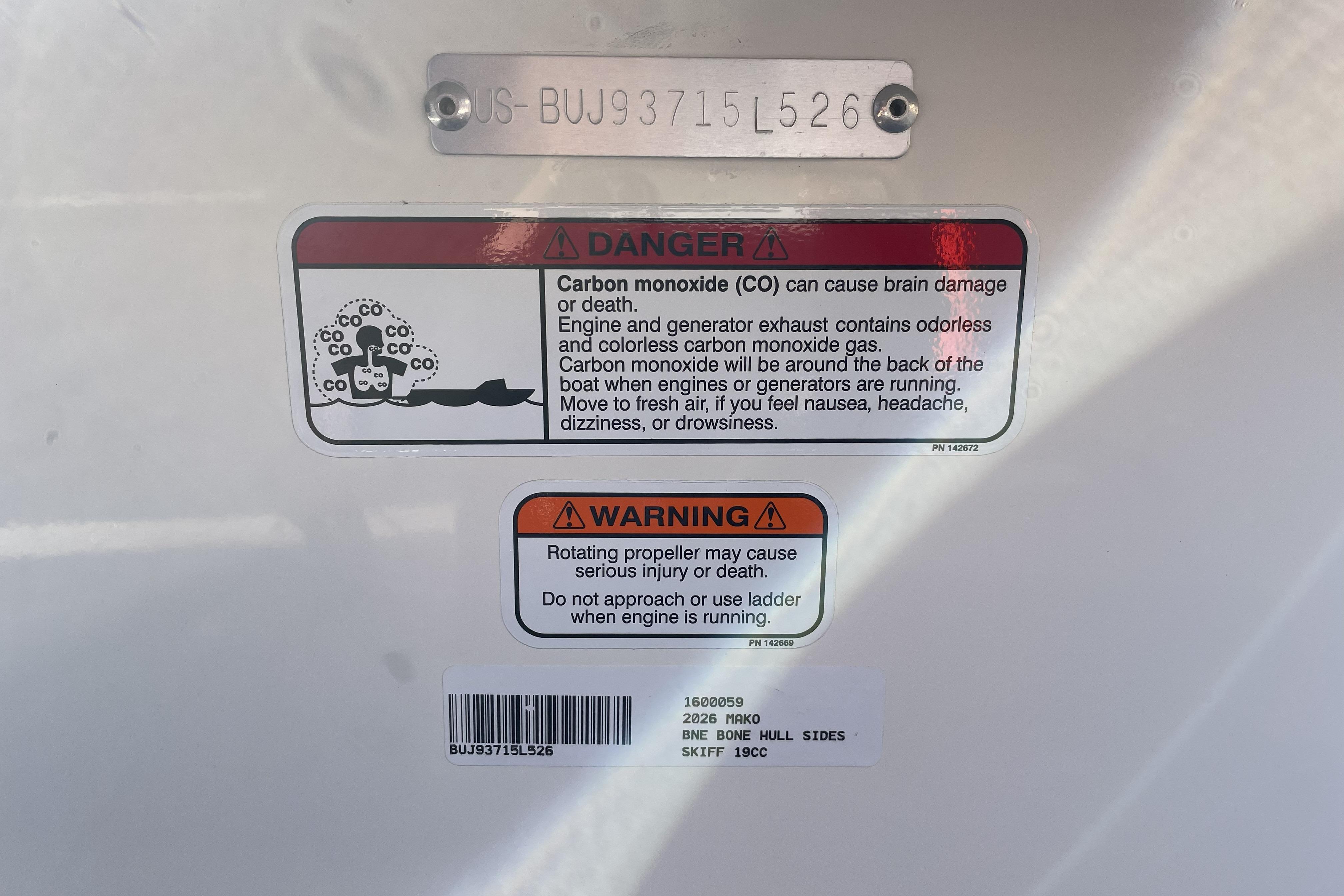 Warning labels on 2026 Mako Pro Skiff 19 CC boat, highlighting carbon monoxide and propeller hazards.
