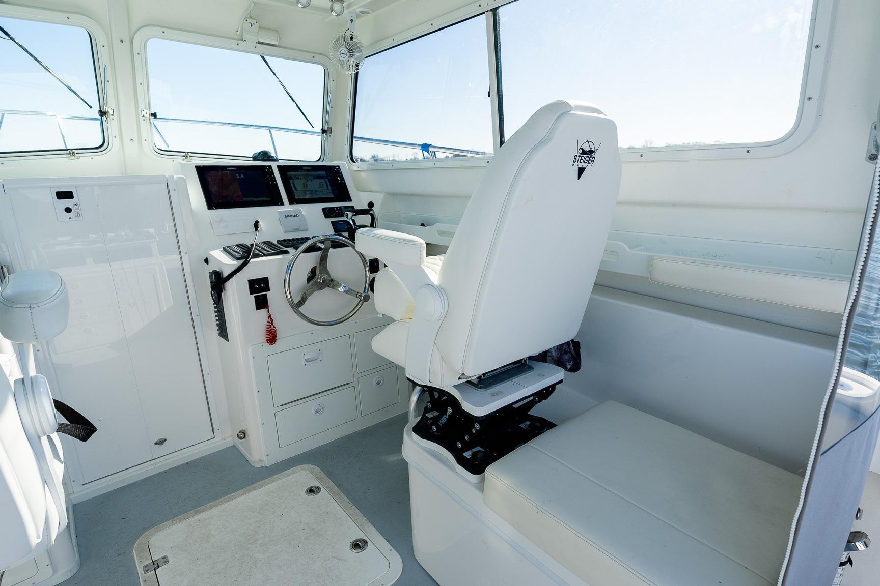 2024 Steiger Craft 31 Fisherman boat interior with helm, steering wheel, and navigation equipment.
