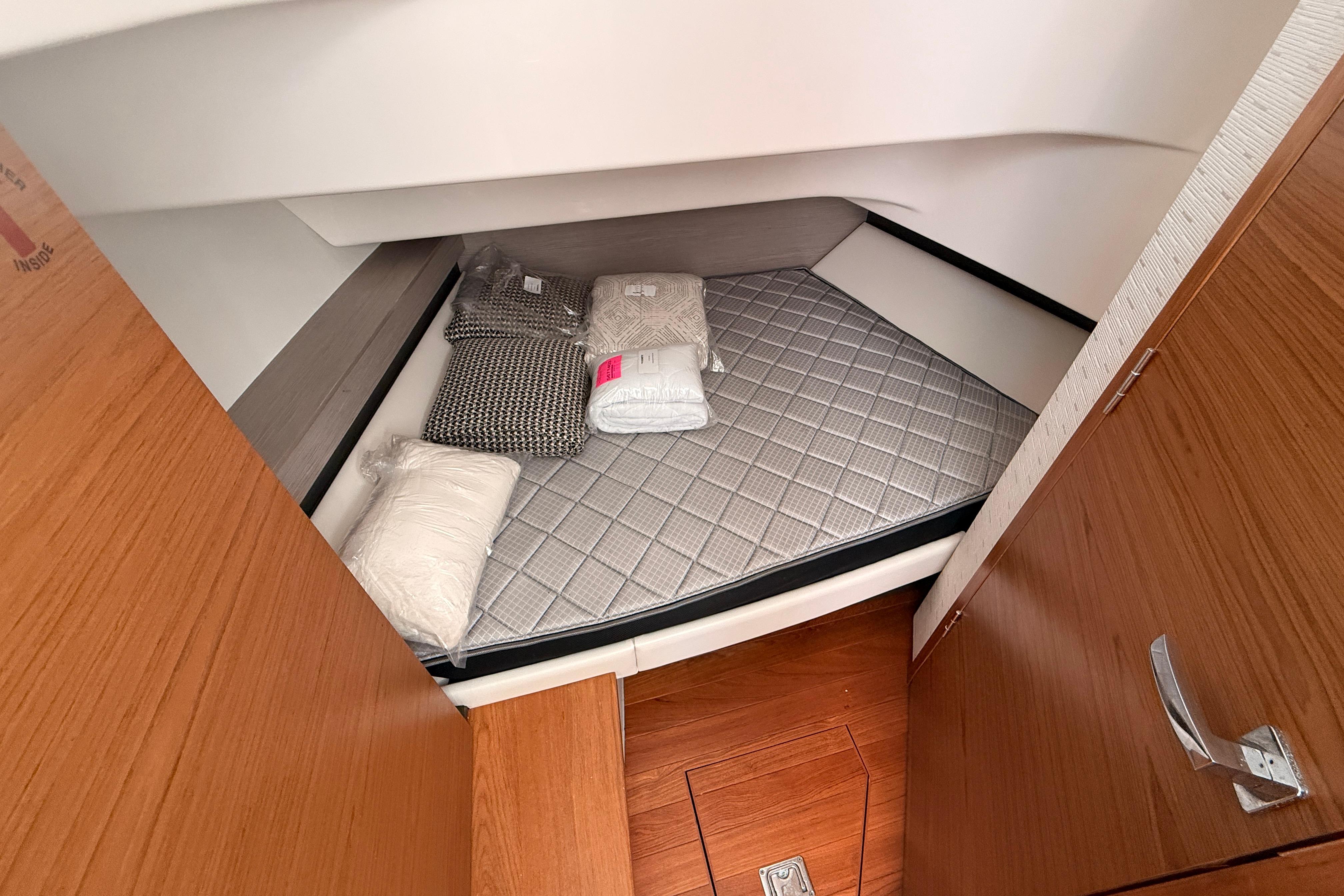 2024 Tiara Yachts 34 LS cabin interior with bed and pillows, showcasing luxury design.