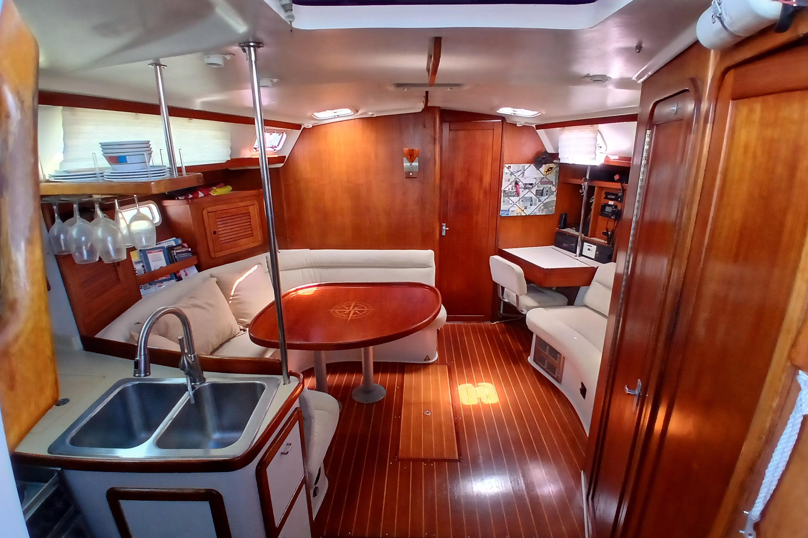 Interior of a 1995 Catalina 42 MkII sailboat with wood finishes and cozy seating.