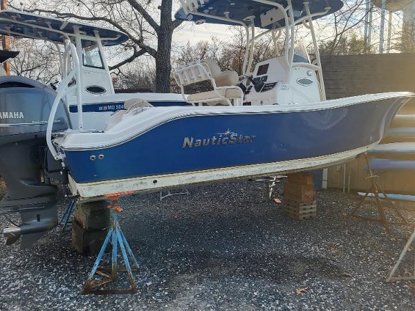 2021 NauticStar 2302 Legacy boat on stands, blue hull, Yamaha outboard motor.