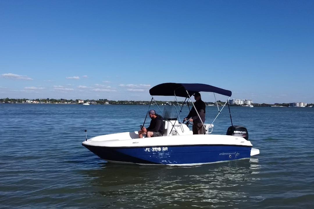 2018 Bayliner Element F16 boat on calm water under clear blue sky.