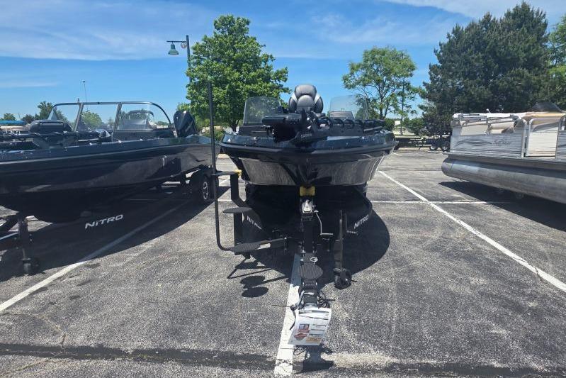 2026 Nitro ZV21 boat on trailer in parking lot, surrounded by trees and clear sky.