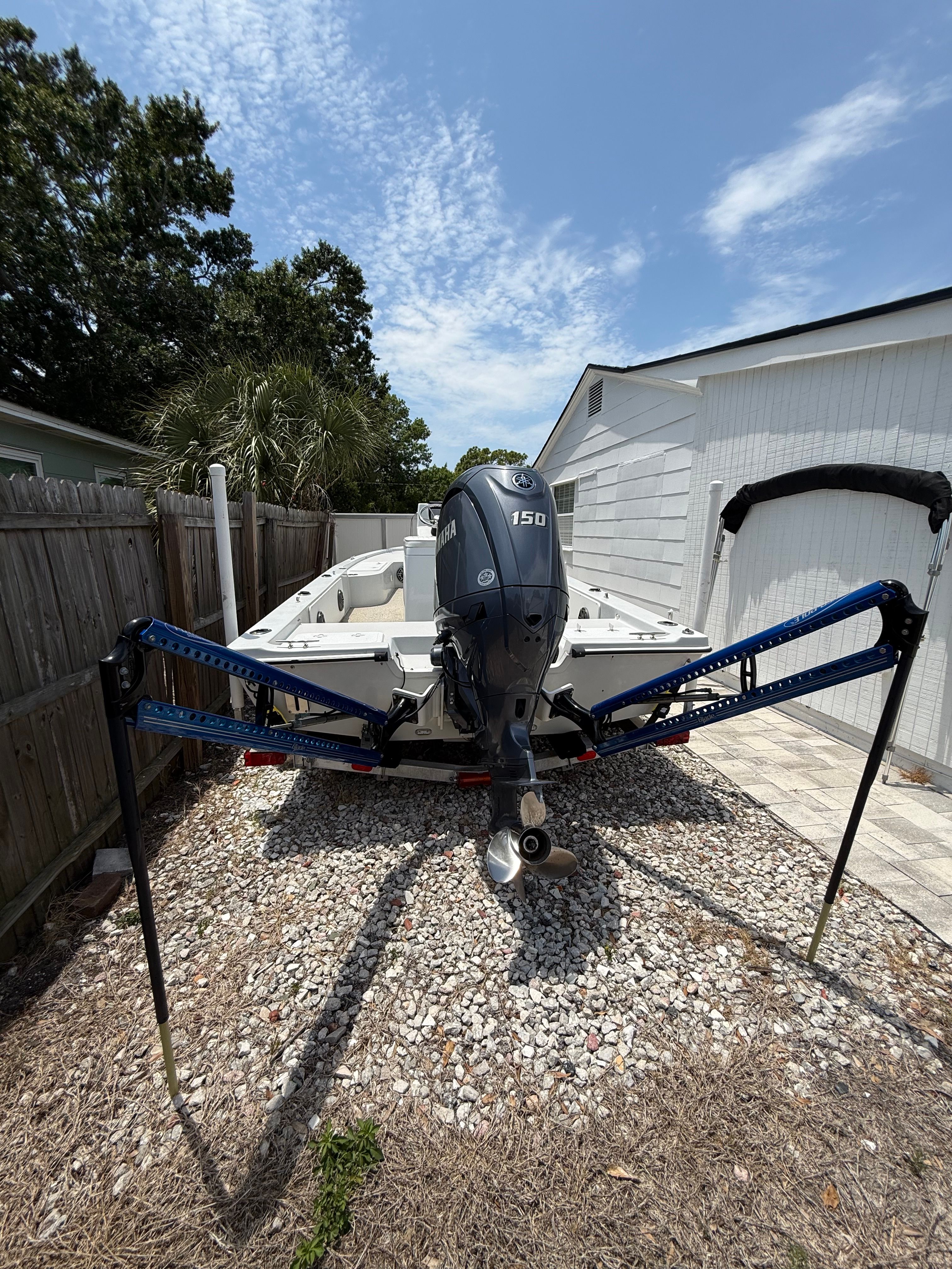 2012 Bay Craft 21 boat with outboard motor in backyard.
