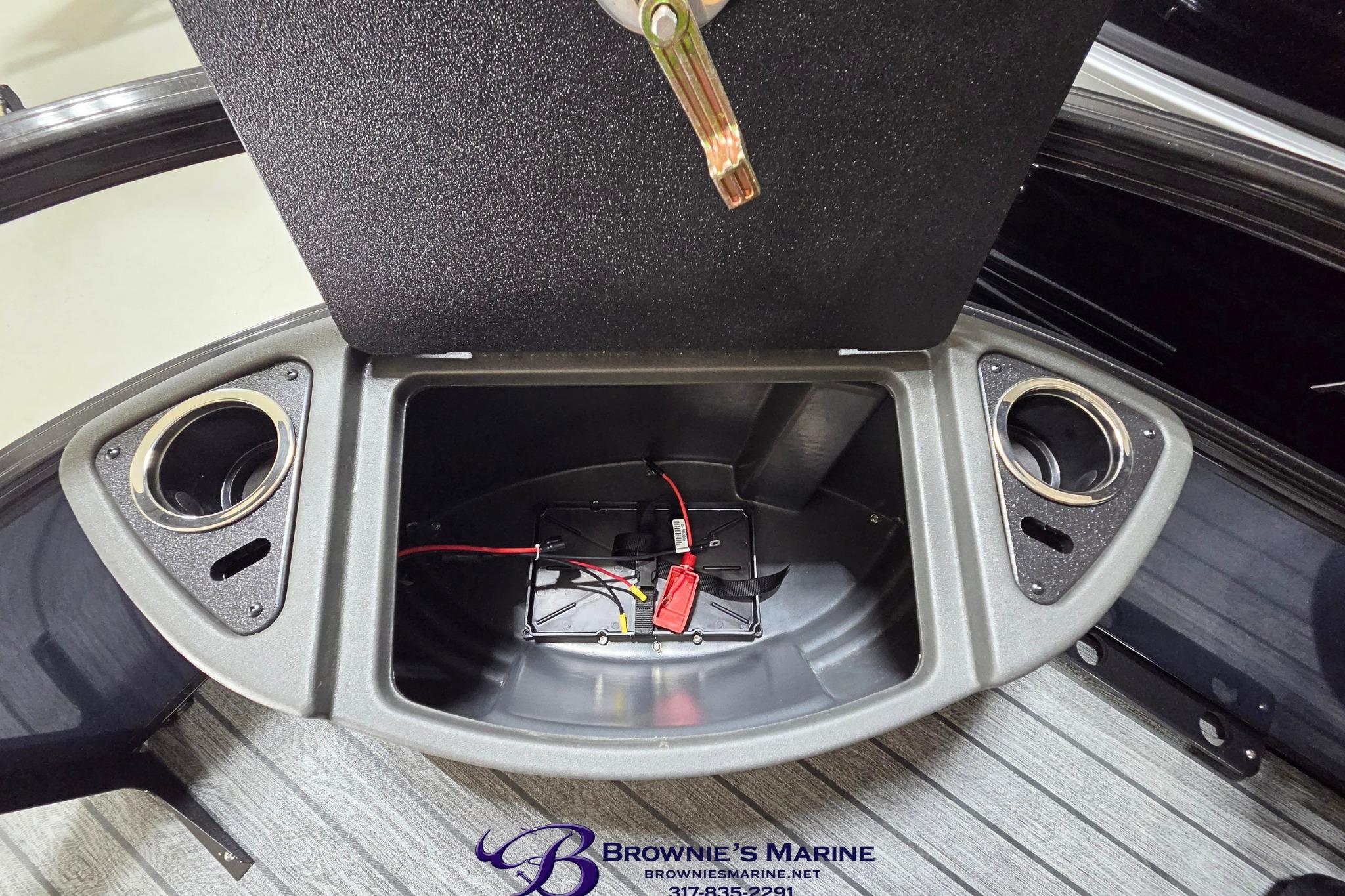 Open storage compartment in 2026 Ranger 220F boat, featuring cup holders and wiring.