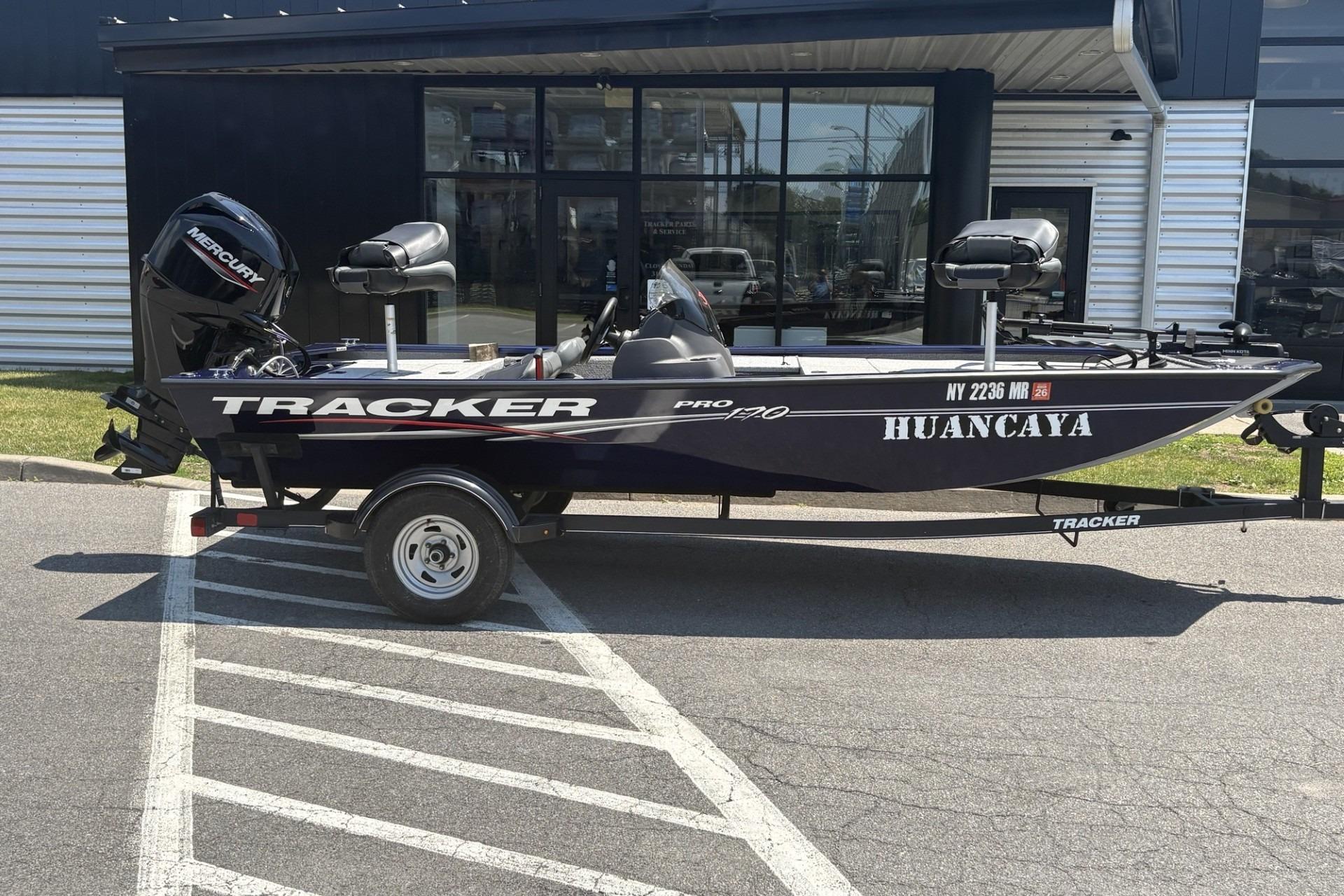 2020 Tracker Pro 170 boat with Mercury engine parked outside a building.