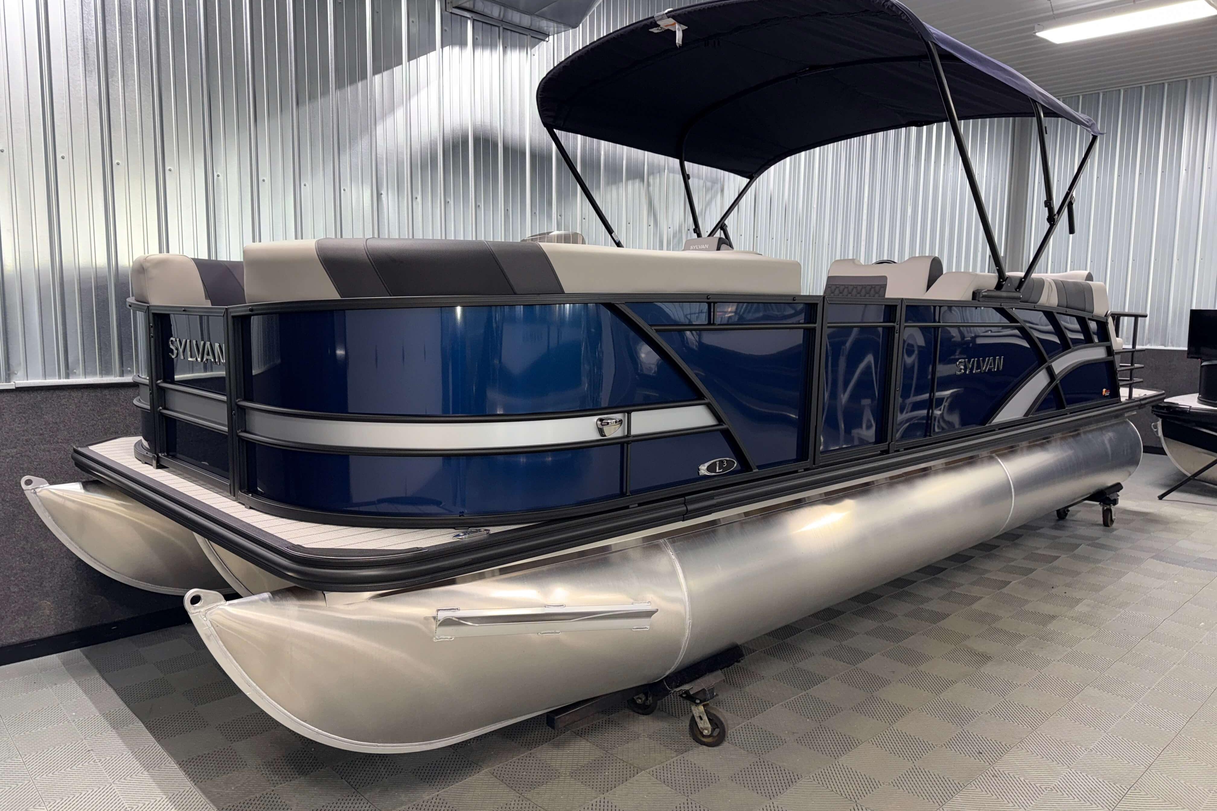 2026 Sylvan L3 SLZ pontoon boat with blue exterior in a showroom.