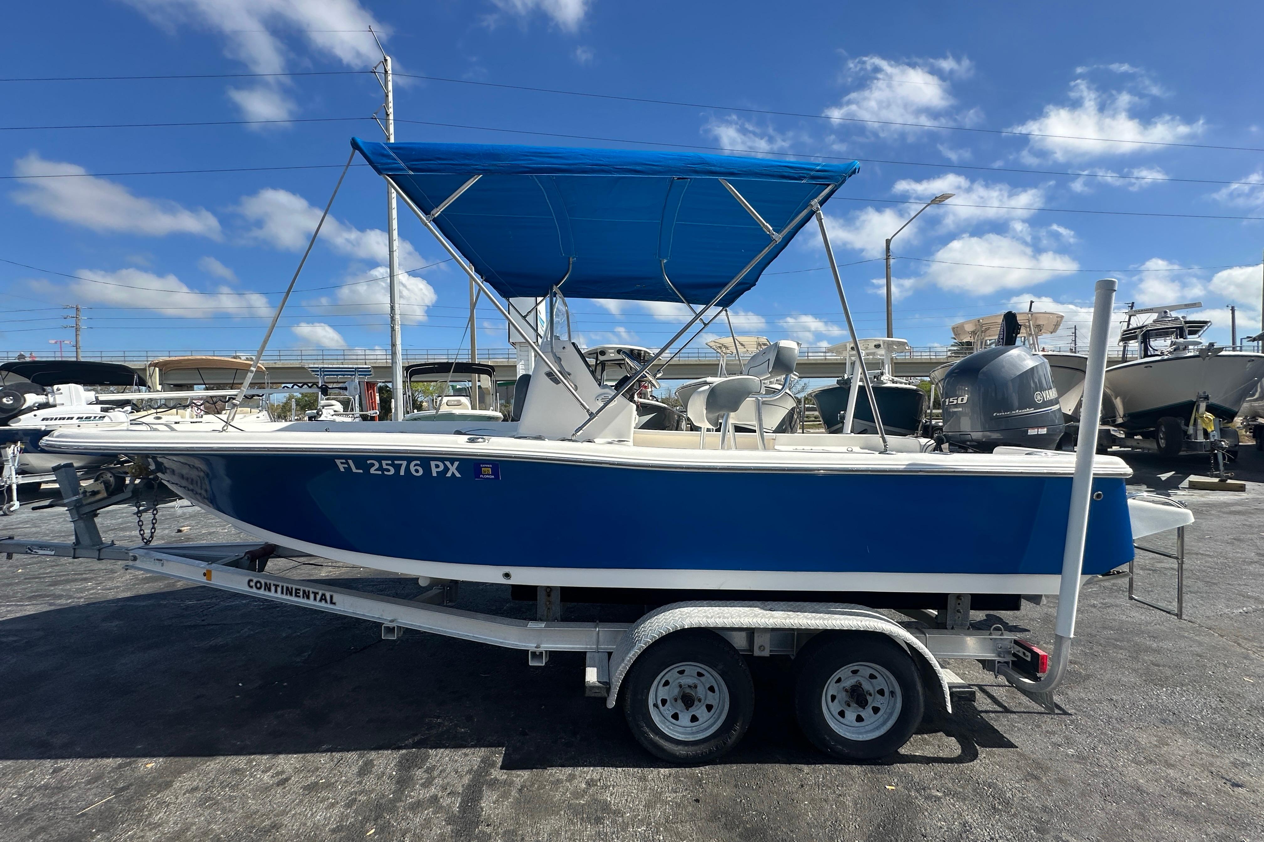 2015 Tidewater 2000 Carolina Bay boat with blue canopy on trailer, sunny day.