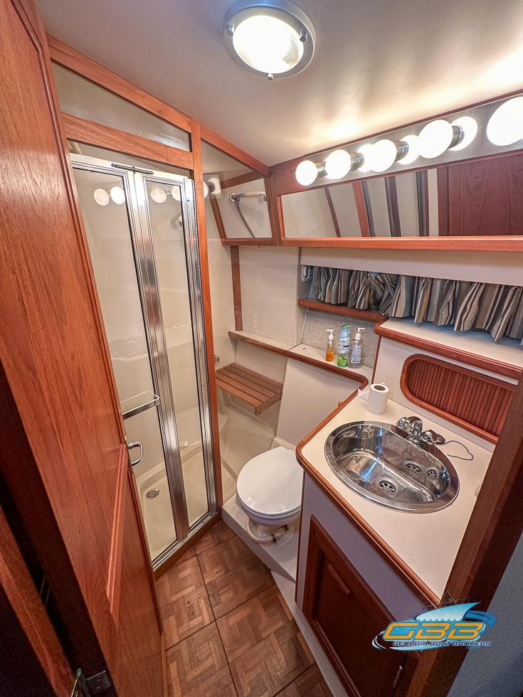 1989 Carver 3807 Aft Cabin bathroom with shower, sink, and wood accents.