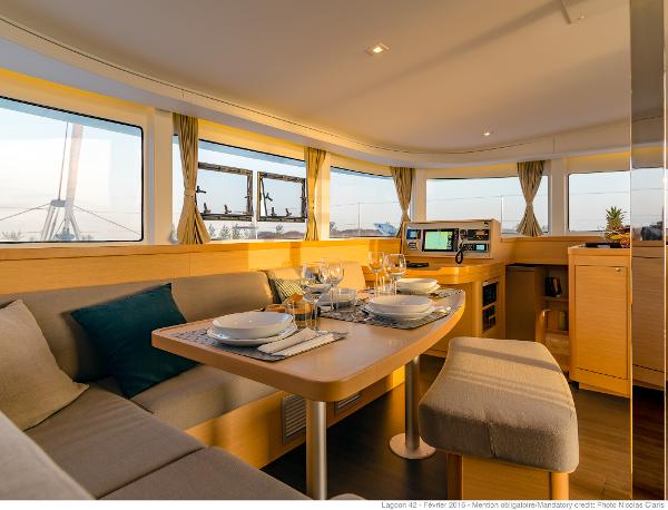 Luxurious interior of 2025 Lagoon 42 Millenium yacht with elegant dining area and panoramic windows.