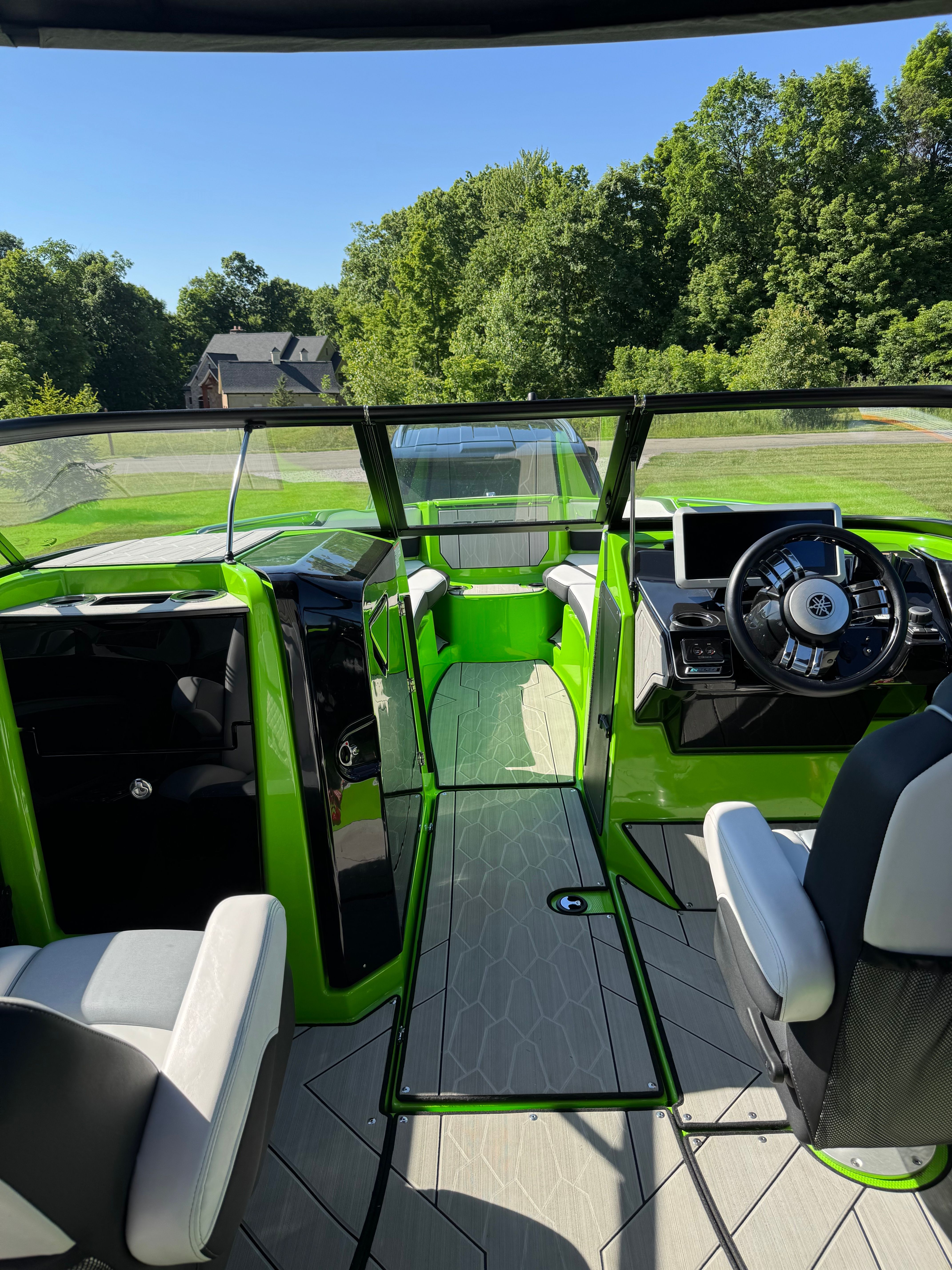The image shows the cockpit of a 2022 Yamaha Boats 255XD with green and black interior.