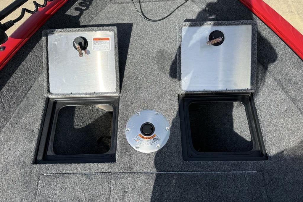 2026 Tracker Pro Guide V-16 SC boat storage compartments with open lids and carpeted flooring.