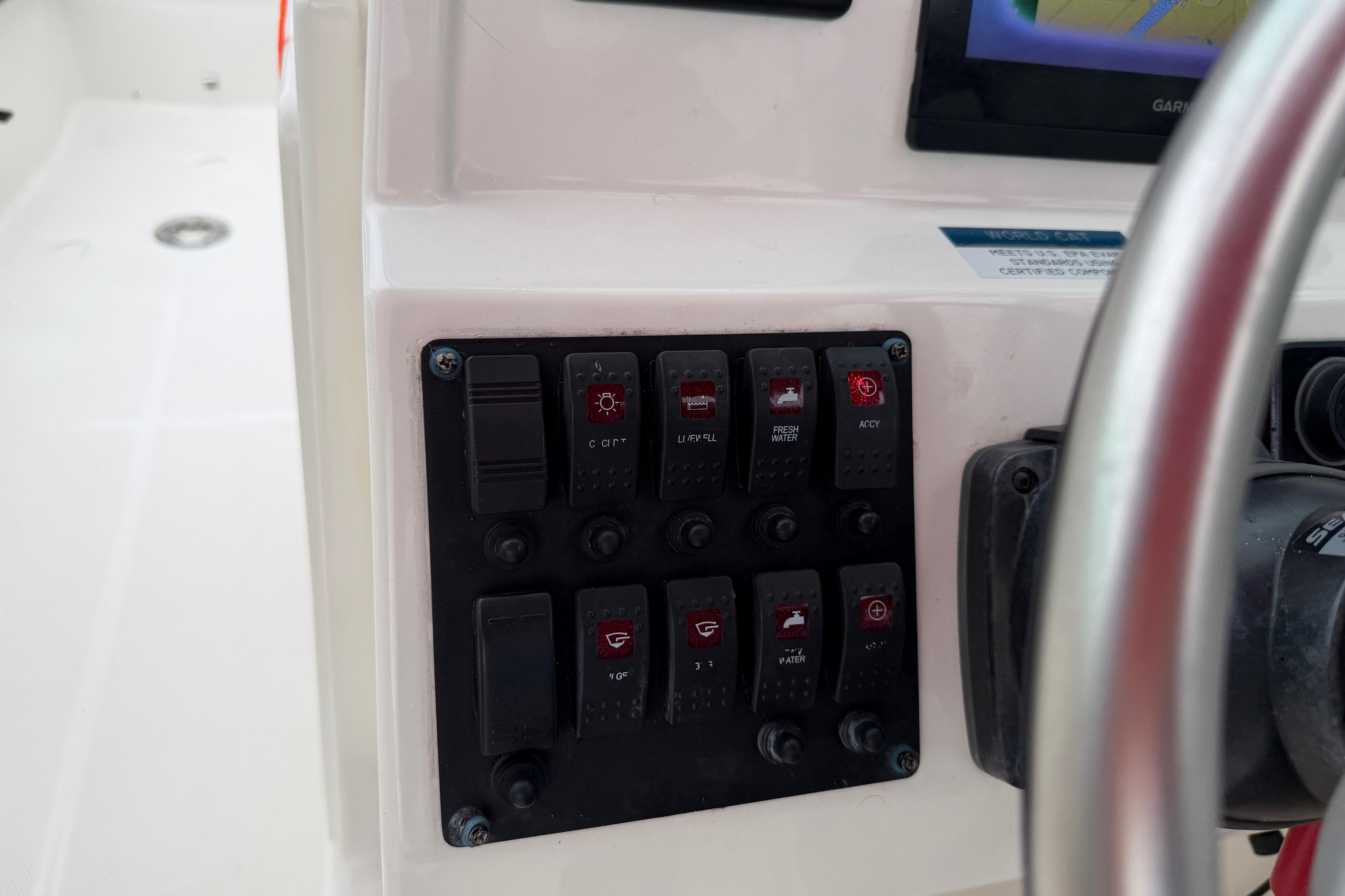 Control panel of a 2019 World Cat 230 DC boat with various switches.