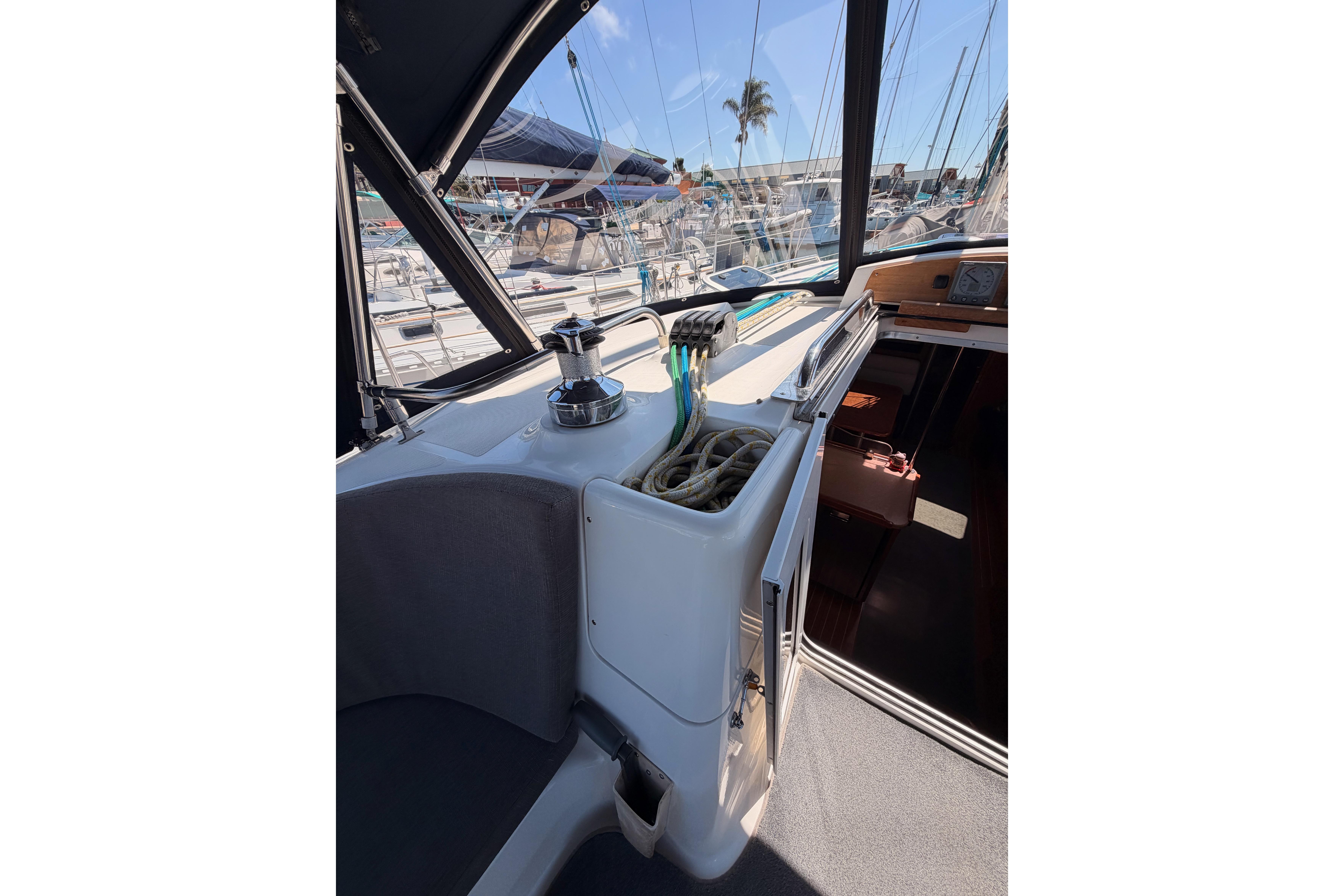 2008 Hunter 45 Deck Salon cockpit with winch, ropes, and marina view.