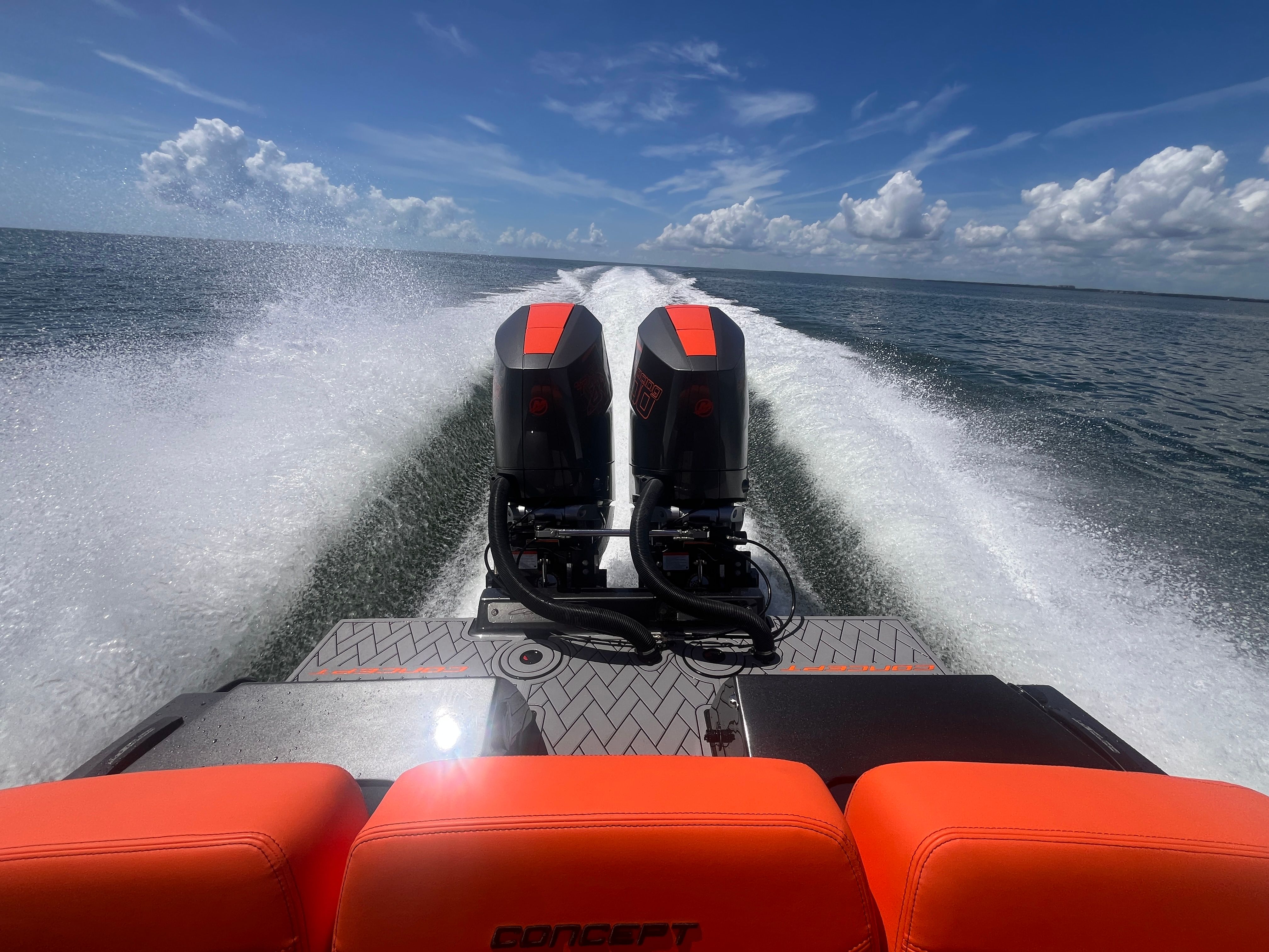 Rear view of a fast boat with twin engines speeding across the water.