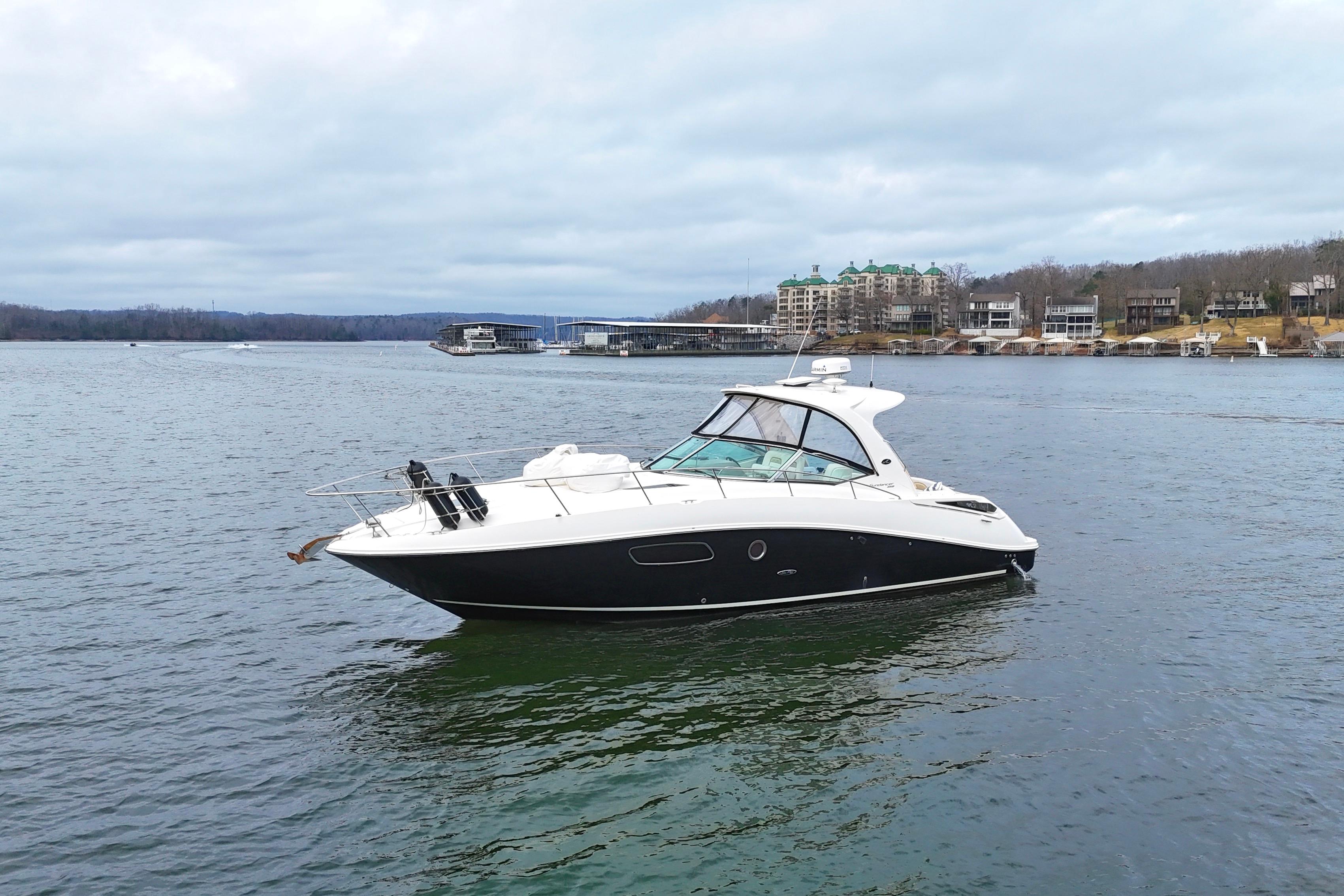 2009 Sea Ray Sundancer 350 yacht on a calm lake with scenic shoreline.