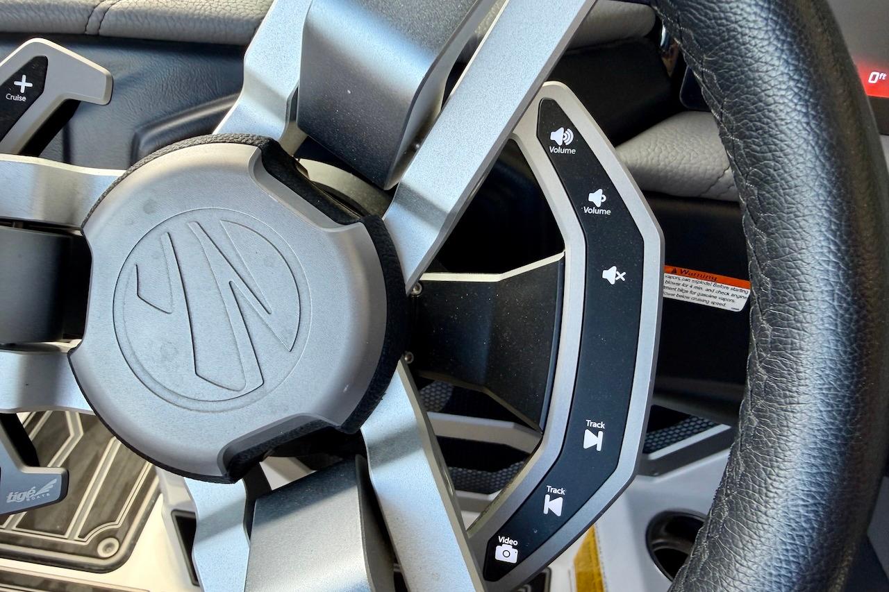 Steering wheel controls of 2025 Tigé Ultré 25ZX boat, featuring volume and track buttons.