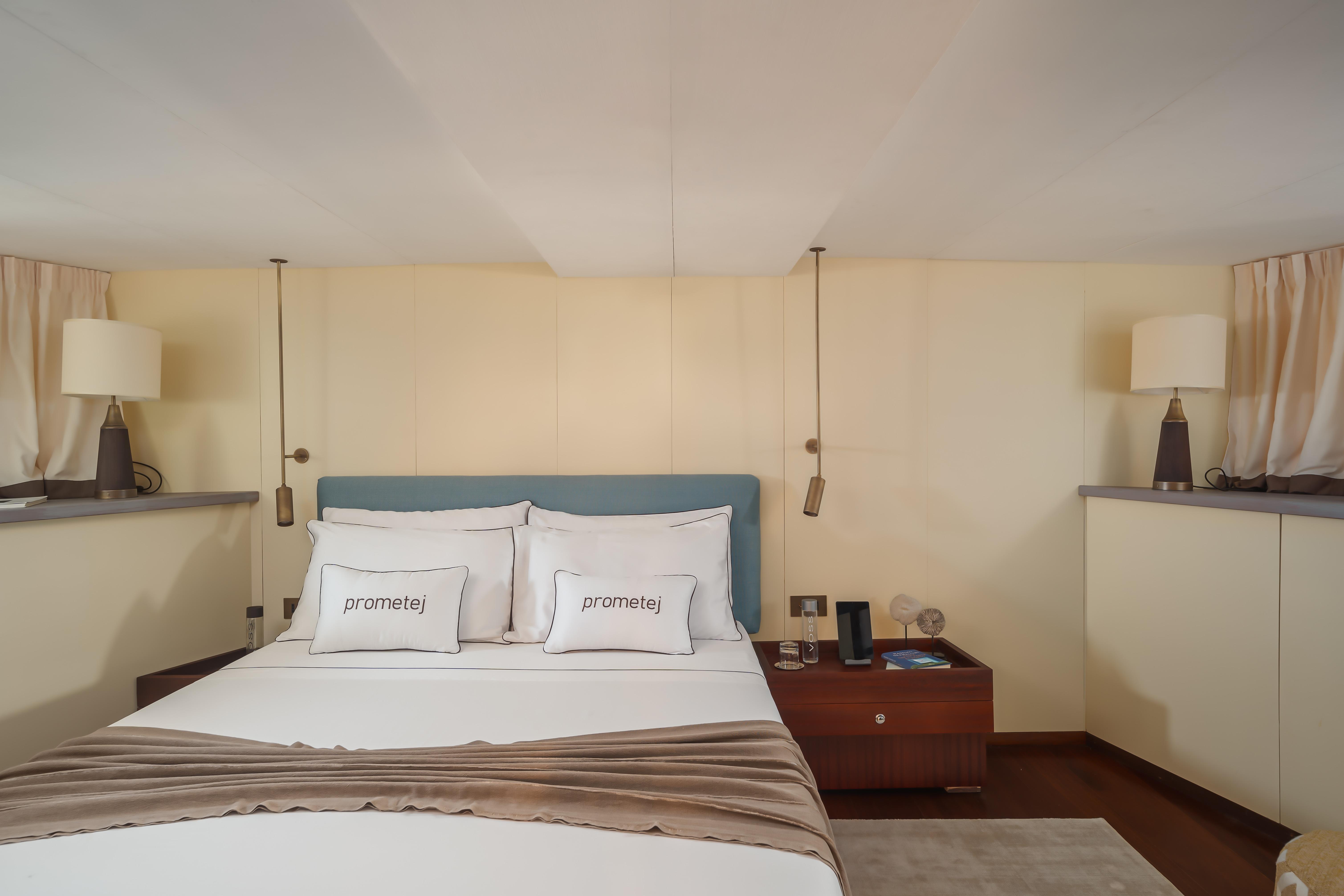 Luxurious bedroom interior on a 1956 custom converted tugboat, featuring elegant decor and cozy bedding.