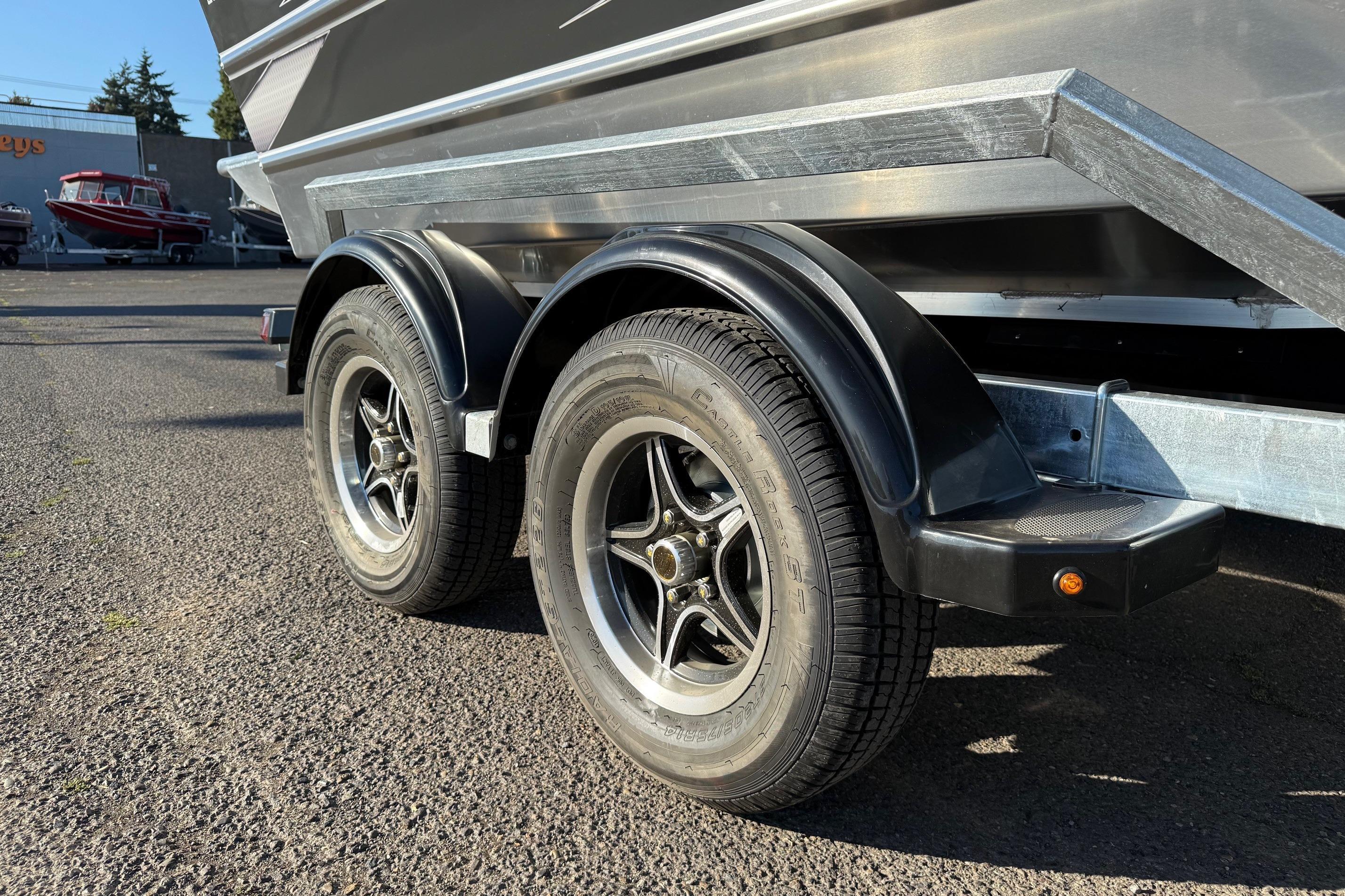 Trailer wheels of a 2026 Thunder Jet 200 Luxor boat on asphalt surface.