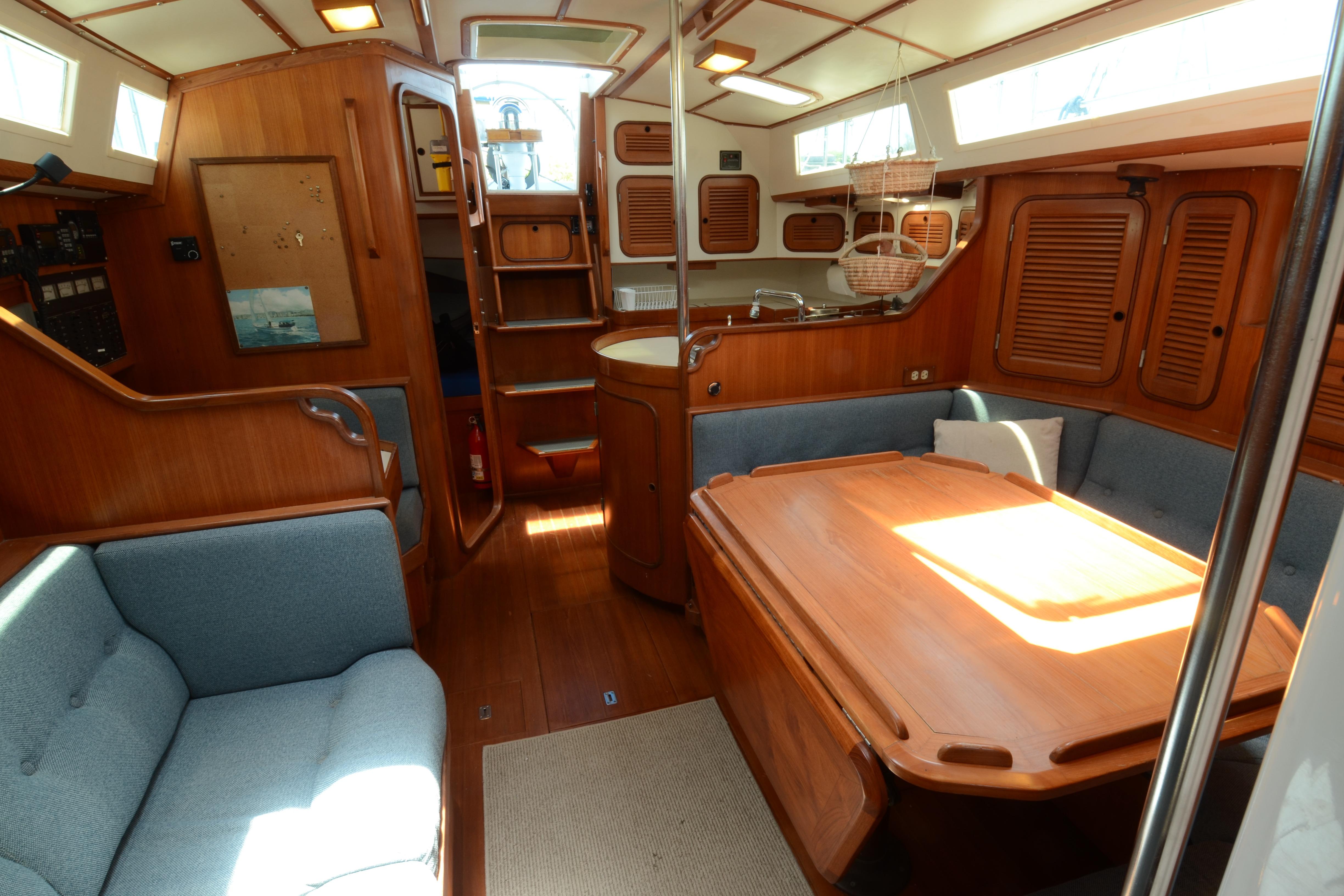 Interior of 1987 Norseman 400 sailboat with wooden furnishings and cozy seating area.