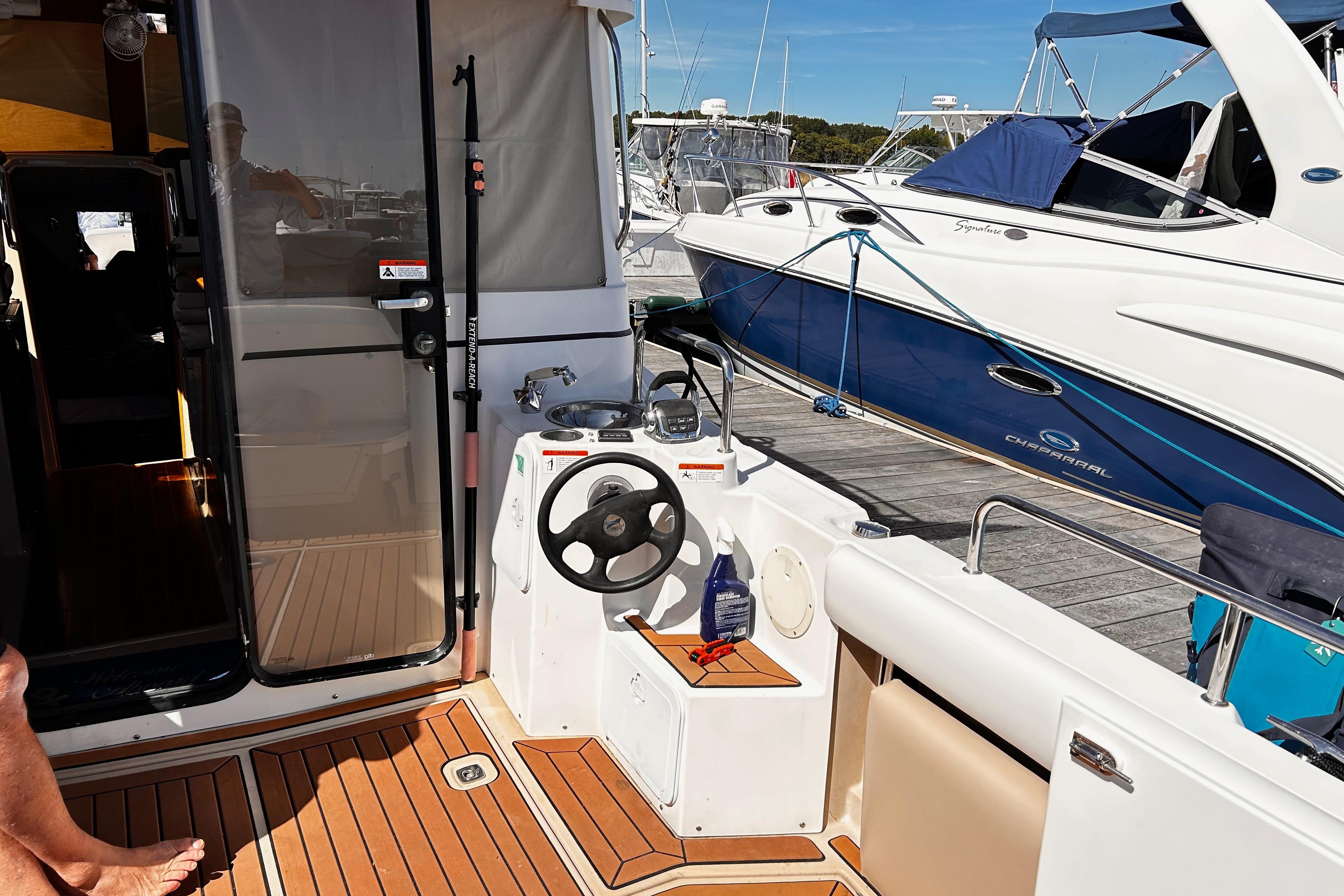 2014 Cutwater C-28 boat interior with helm, docked beside another vessel.
