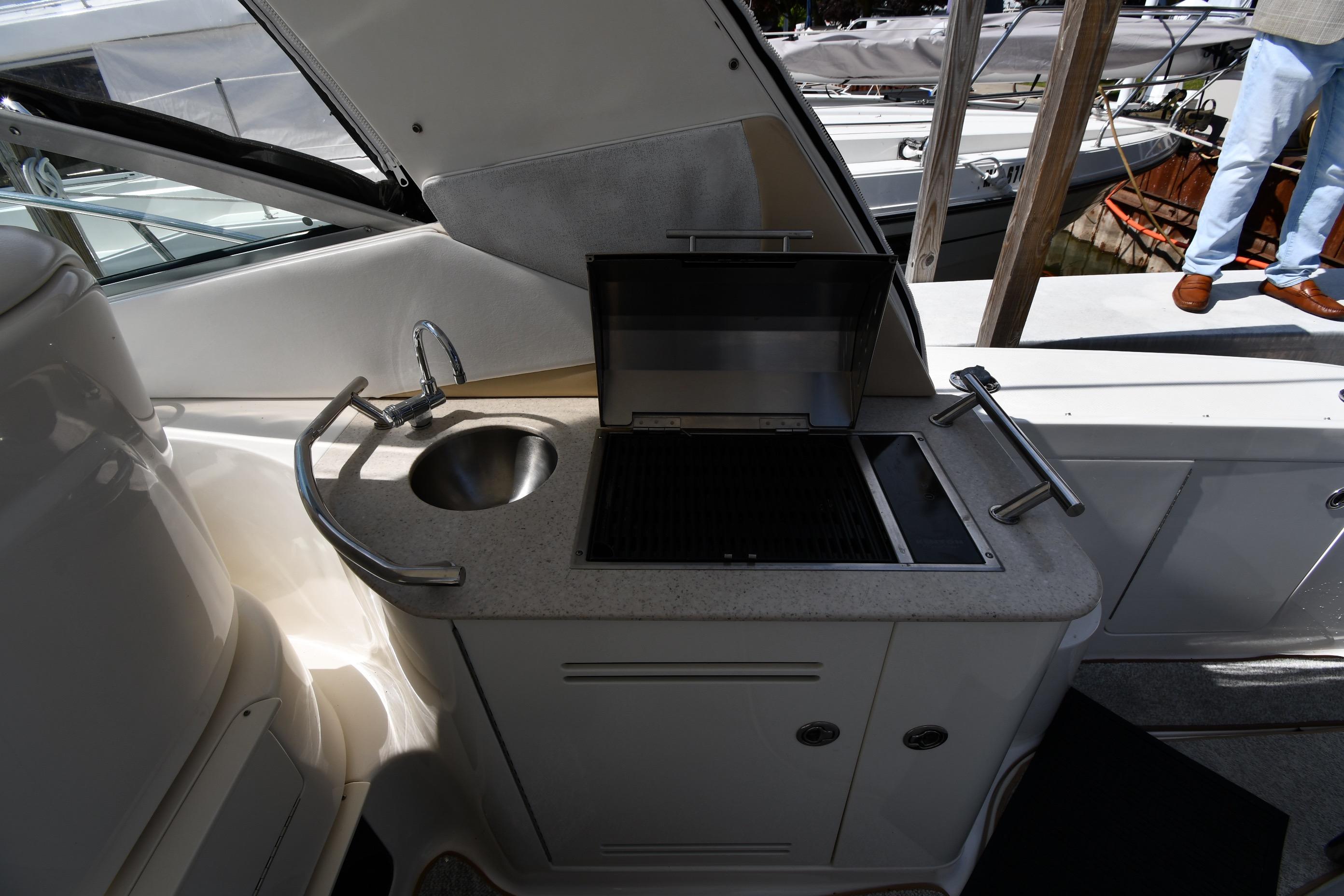 Outdoor kitchenette on a 2008 Sea Ray Sundancer 350 yacht with sink and grill.