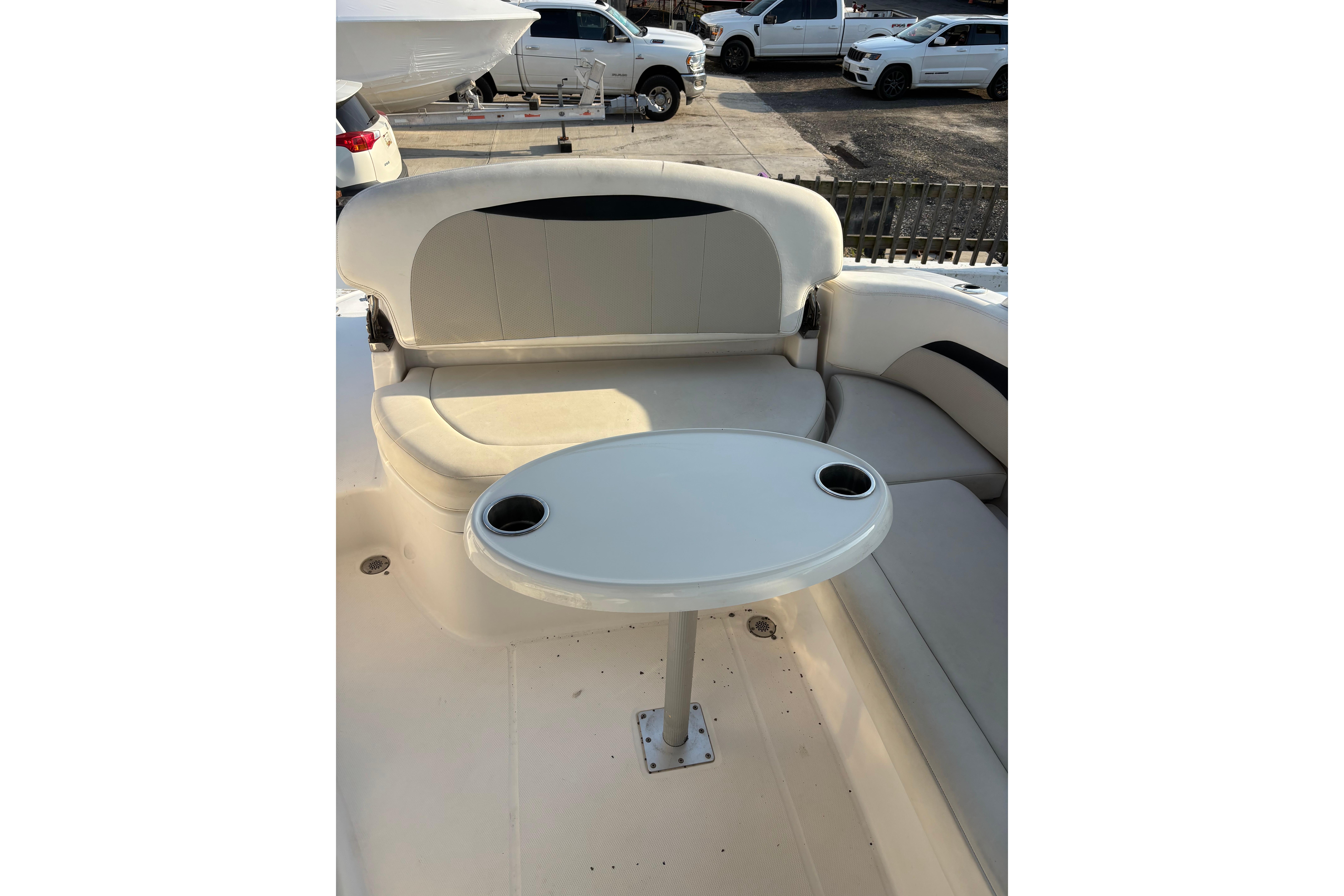 Interior seating area of 2012 Chaparral 267 SSX boat with table and cup holders.