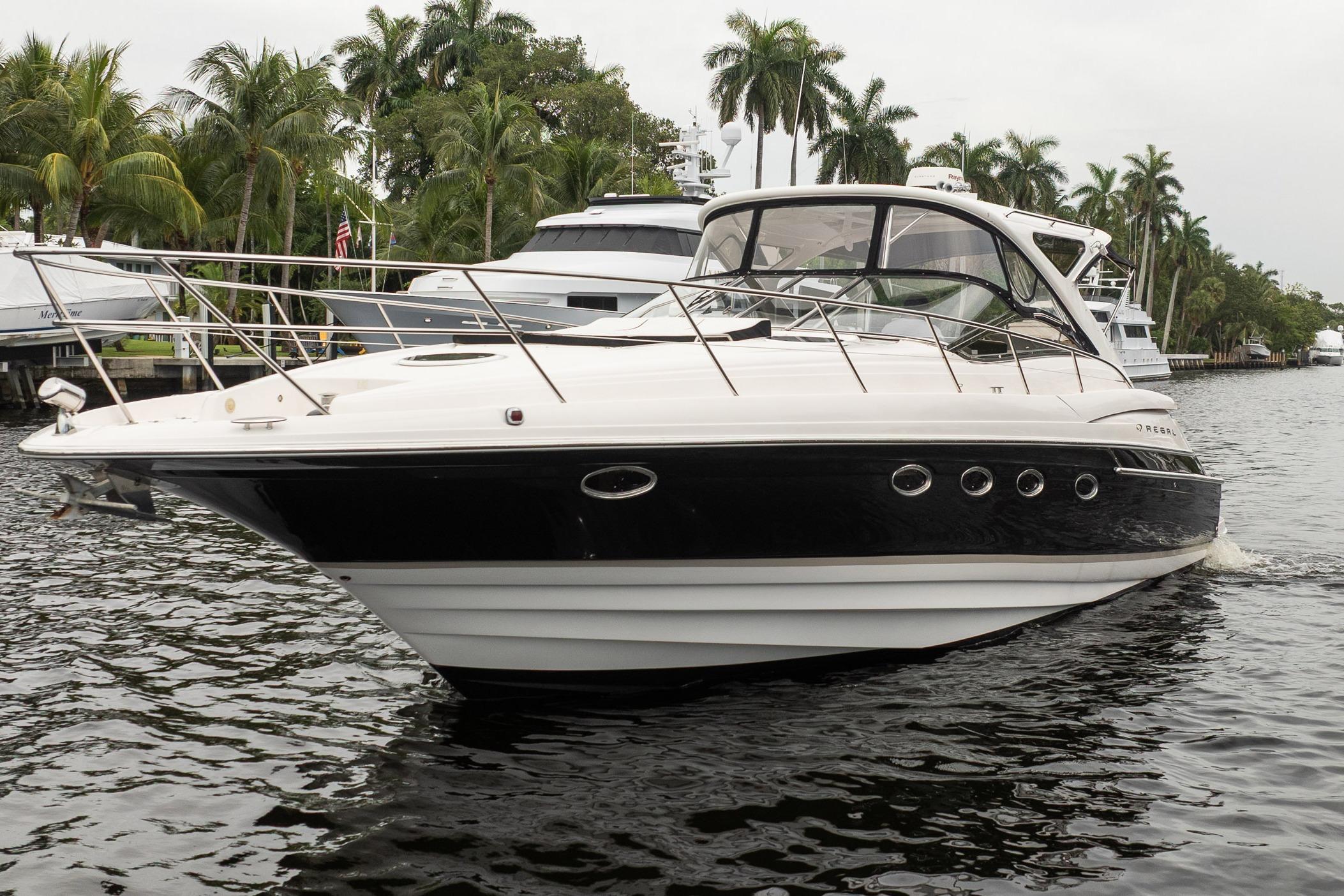 2008 Regal Commodore 4460 yacht cruising on a tropical waterway with palm trees.