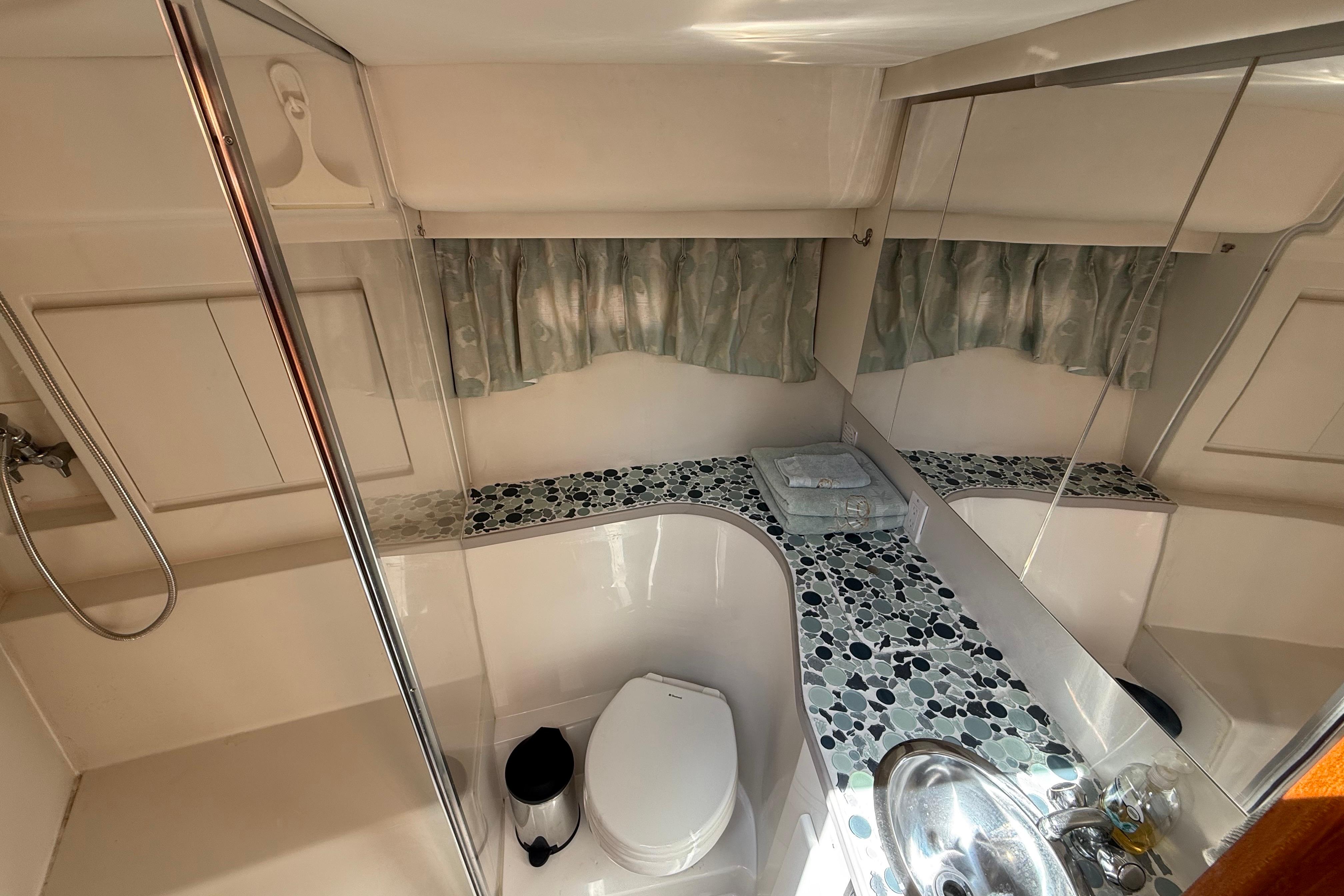 Bathroom interior of 1995 Carver 370 Voyager yacht with modern fixtures and mosaic countertop.