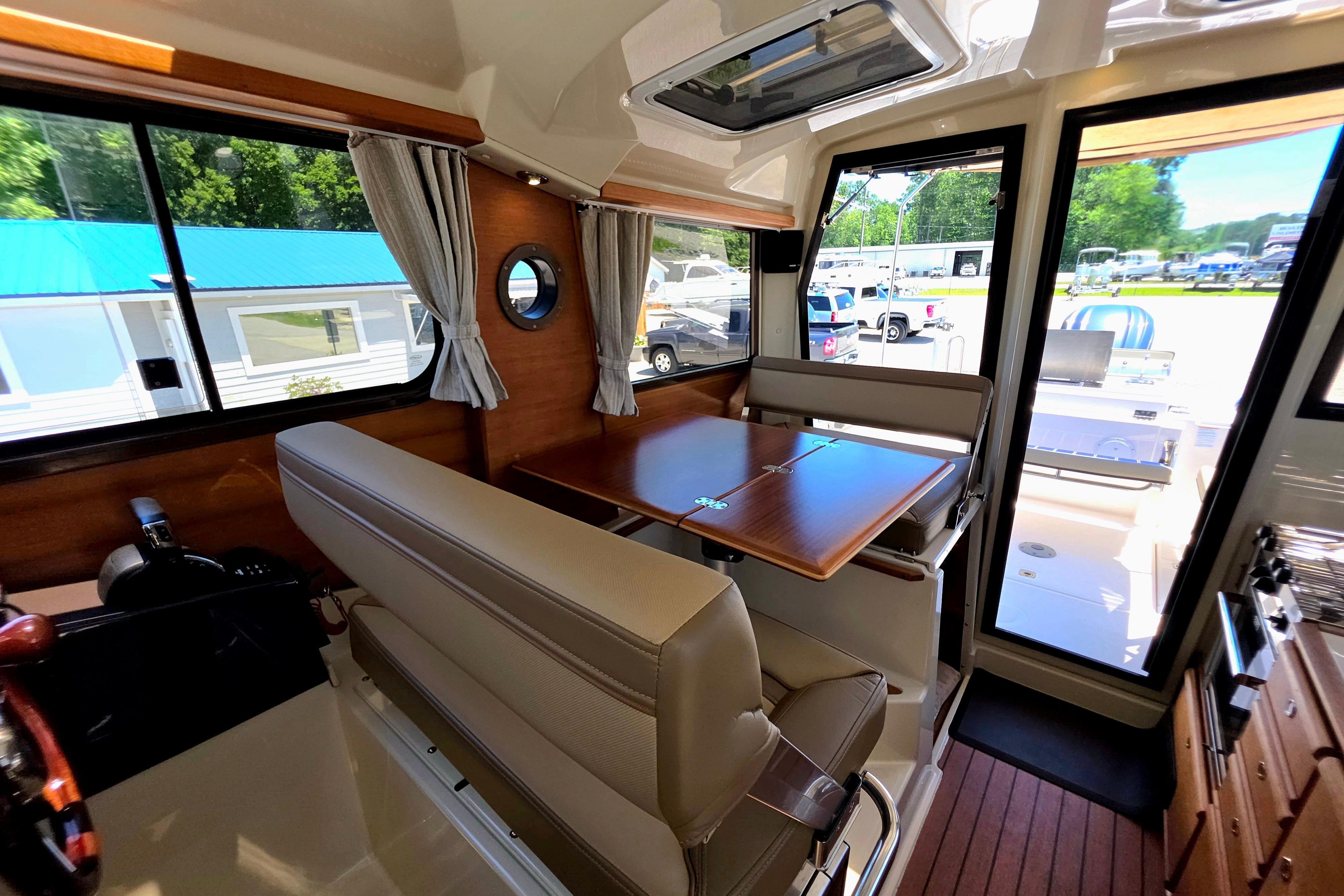 Interior of 2021 Ranger Tug R27 with dining area and large windows.