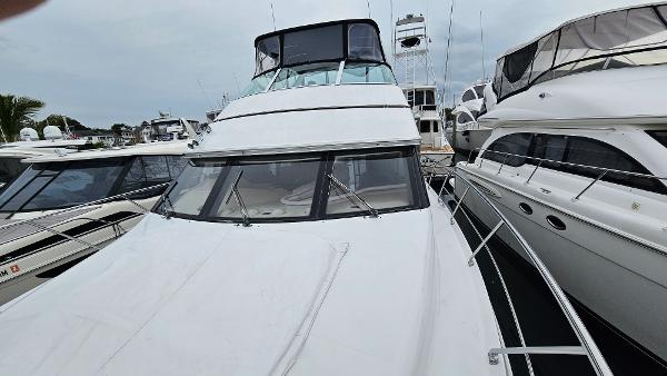 2000 Carver 450 Voyager Pilothouse yacht docked at marina, front view.