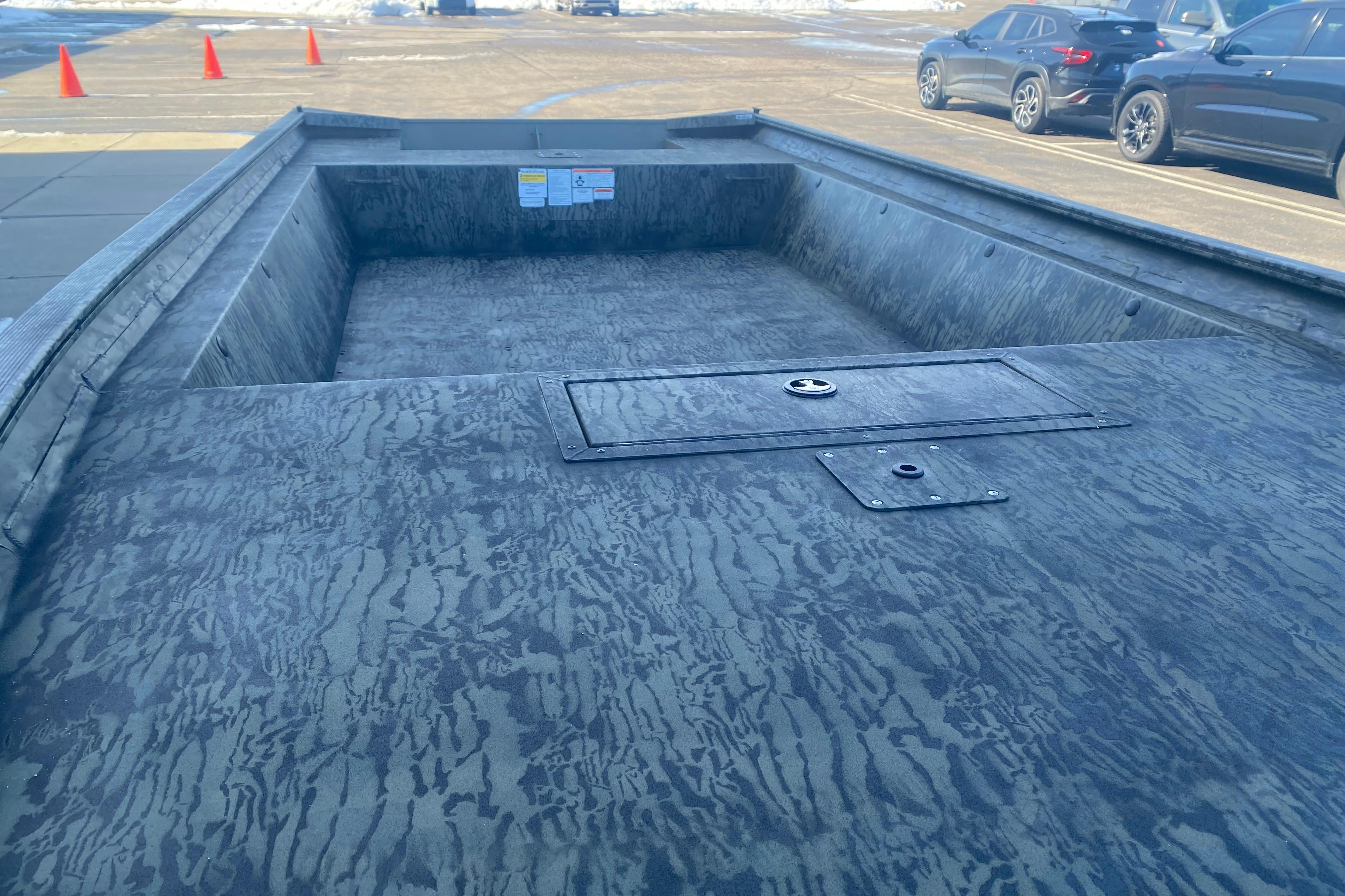 2026 Tracker Grizzly 1860 Utility boat with textured interior, parked outdoors.