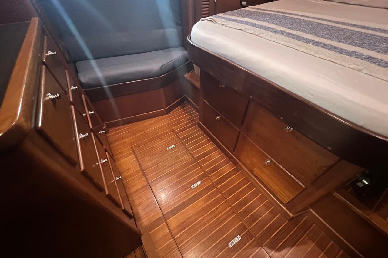 Cozy cabin interior of 1998 Nordhavn 46 yacht with wooden flooring and ample storage.