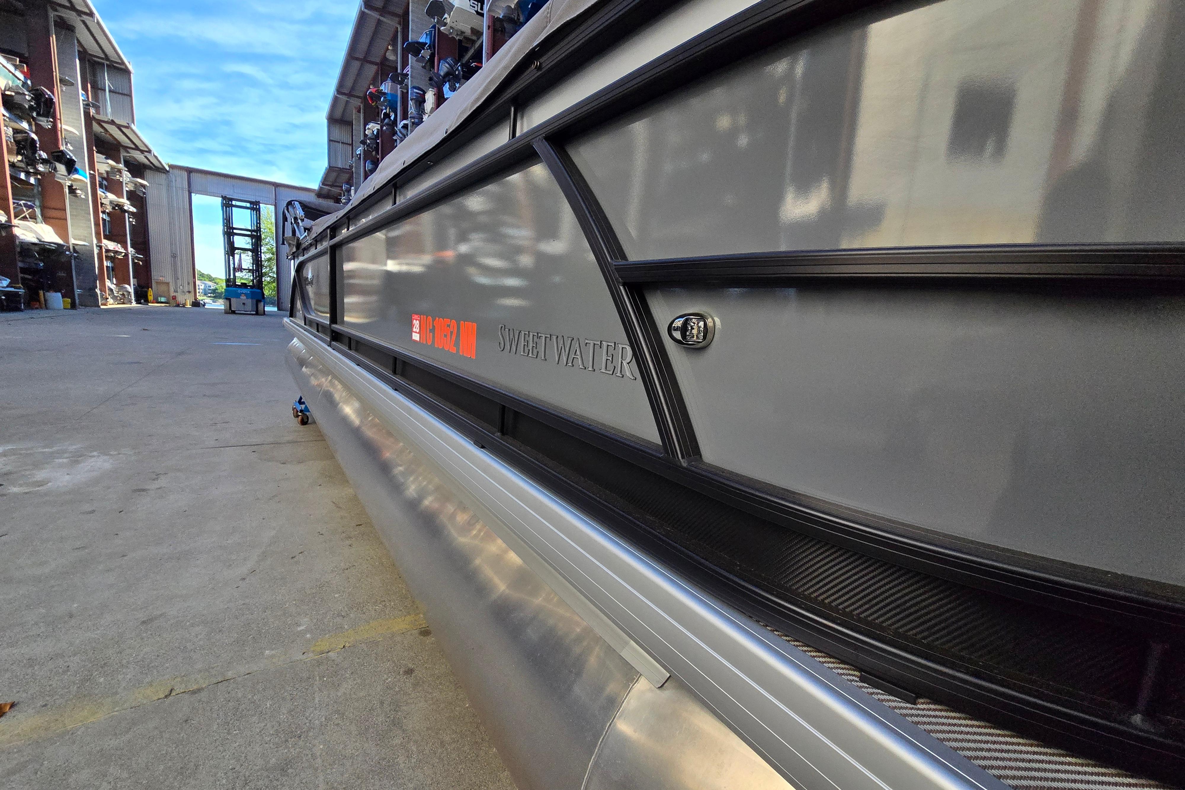 2024 Godfrey Sweetwater 2486 SB pontoon boat in a marina storage area.