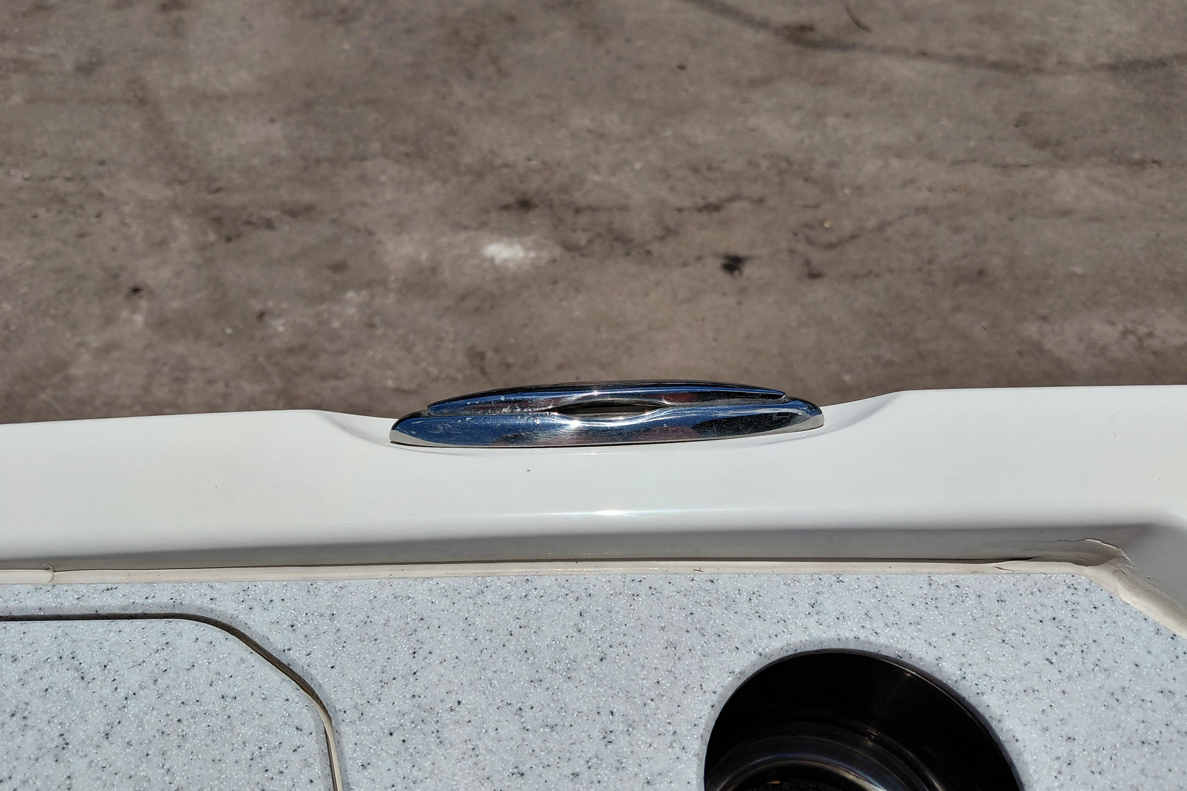 Chrome detail on 2023 Stingray 206 CC boat against textured surface.