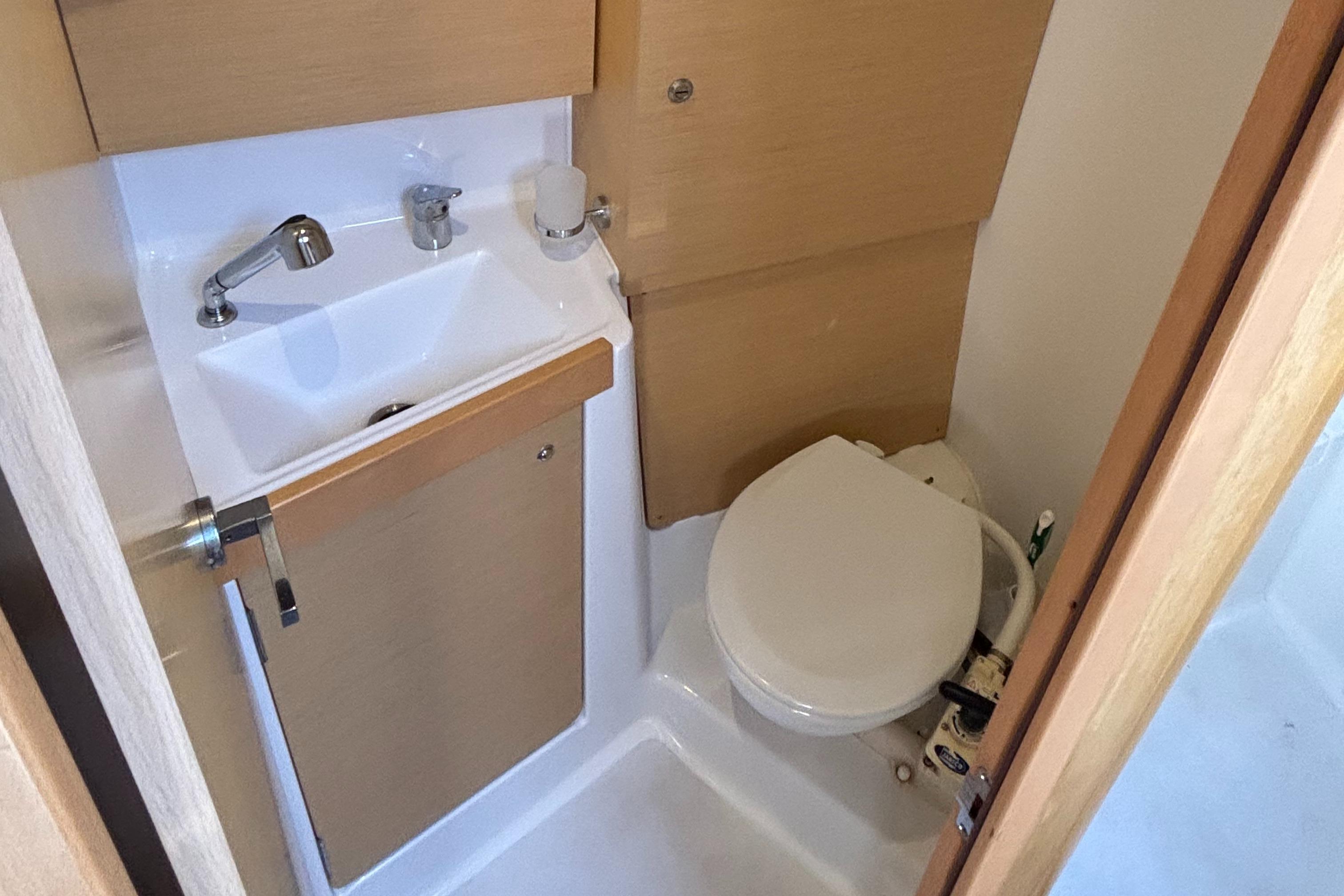 Compact bathroom in 2015 Beneteau Oceanis 35 sailboat with sink and toilet.