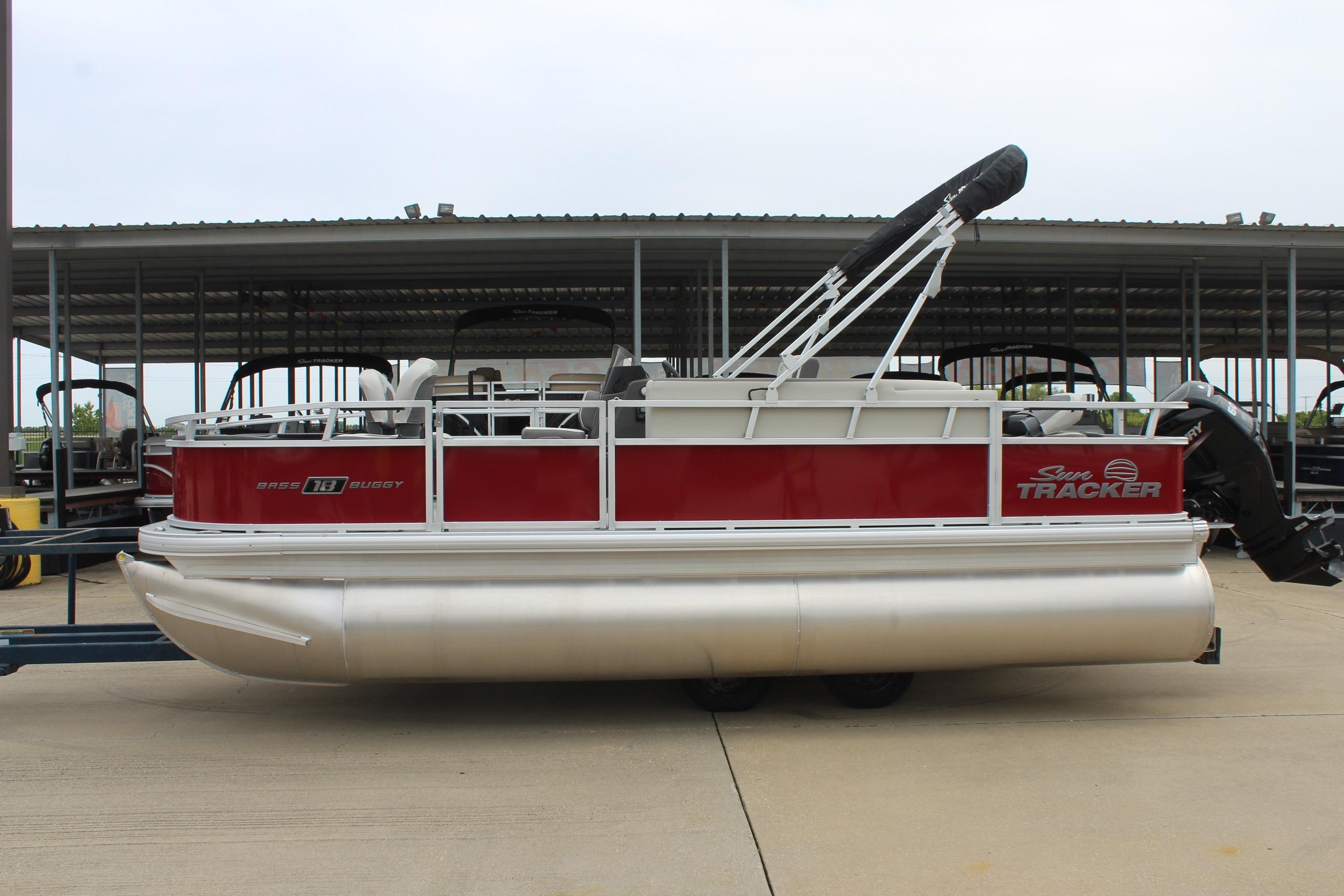 2026 Sun Tracker Bass Buggy 18 DLX pontoon boat in storage facility.