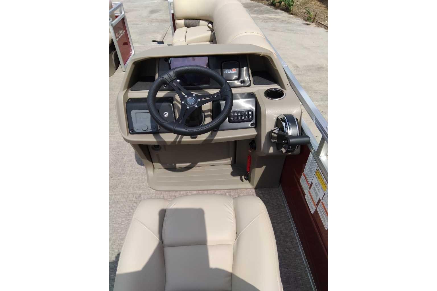 2025 Sun Tracker Party Barge 22 DLX helm with steering wheel and controls.
