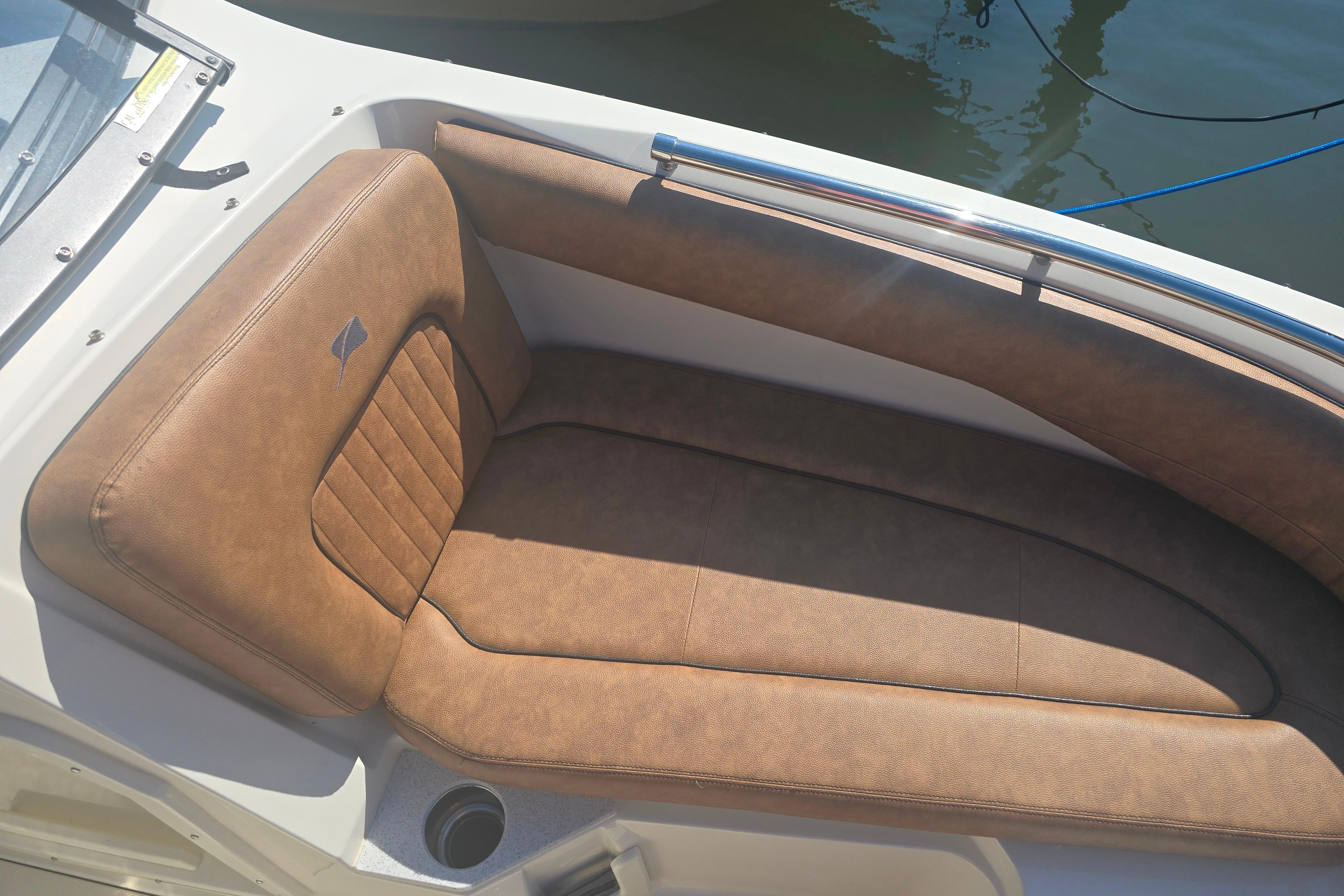 2021 Stingray 201 DC boat with brown cushioned seating, docked on calm water.